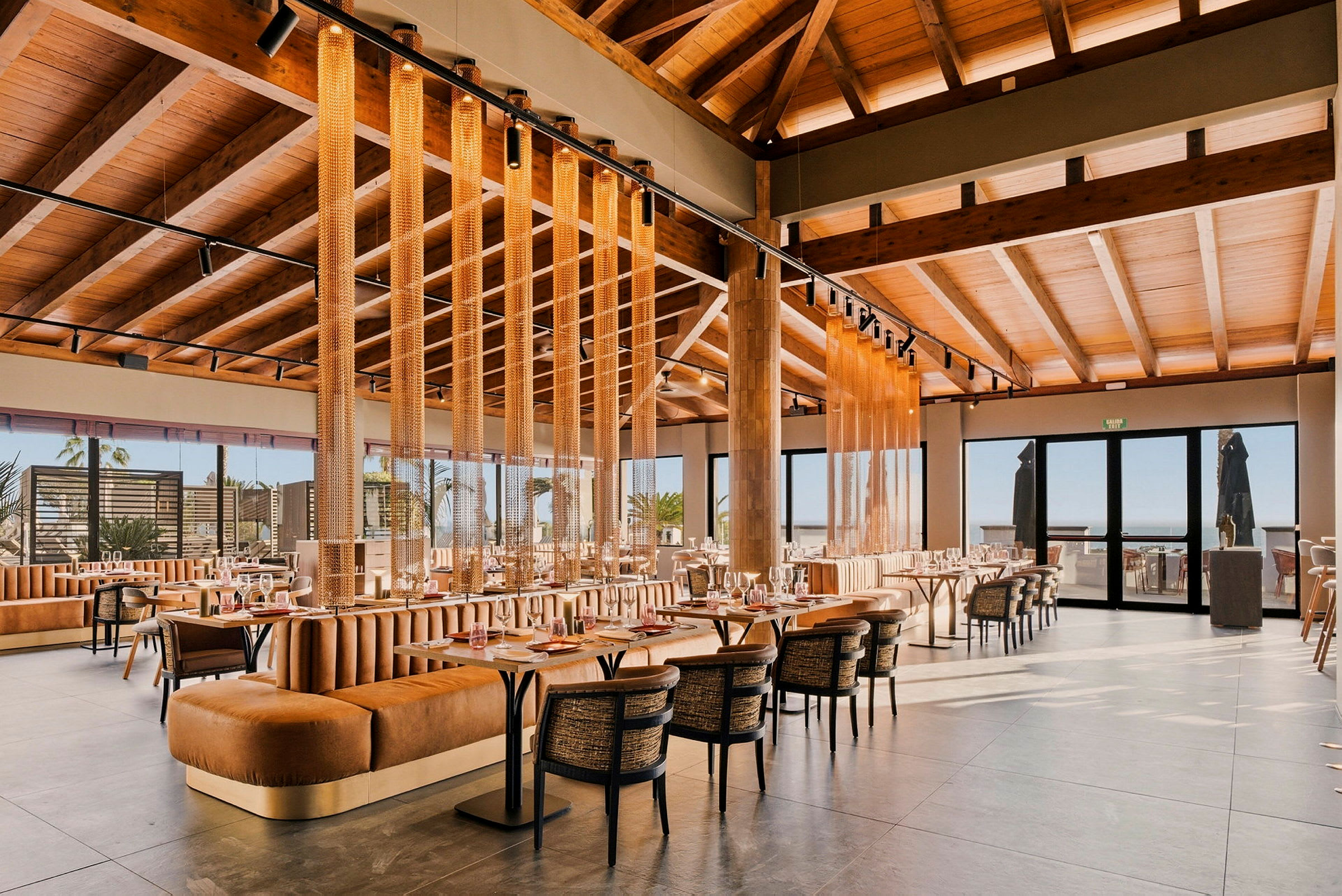 En moderne restaurant med træinteriør, store vinduer og komfortable siddepladser. (AI-genereret tekst)