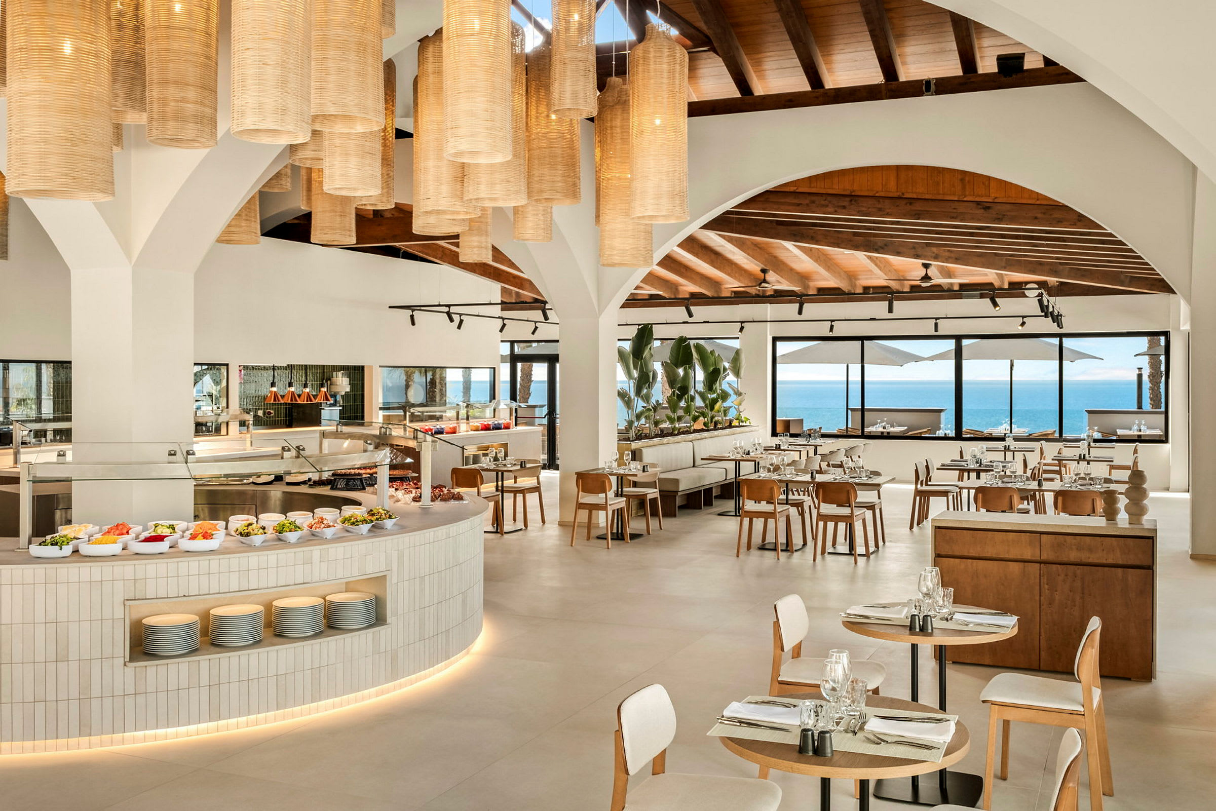 En moderne restaurant med åbent køkken og vinduer med havudsigt. (AI-genereret tekst)