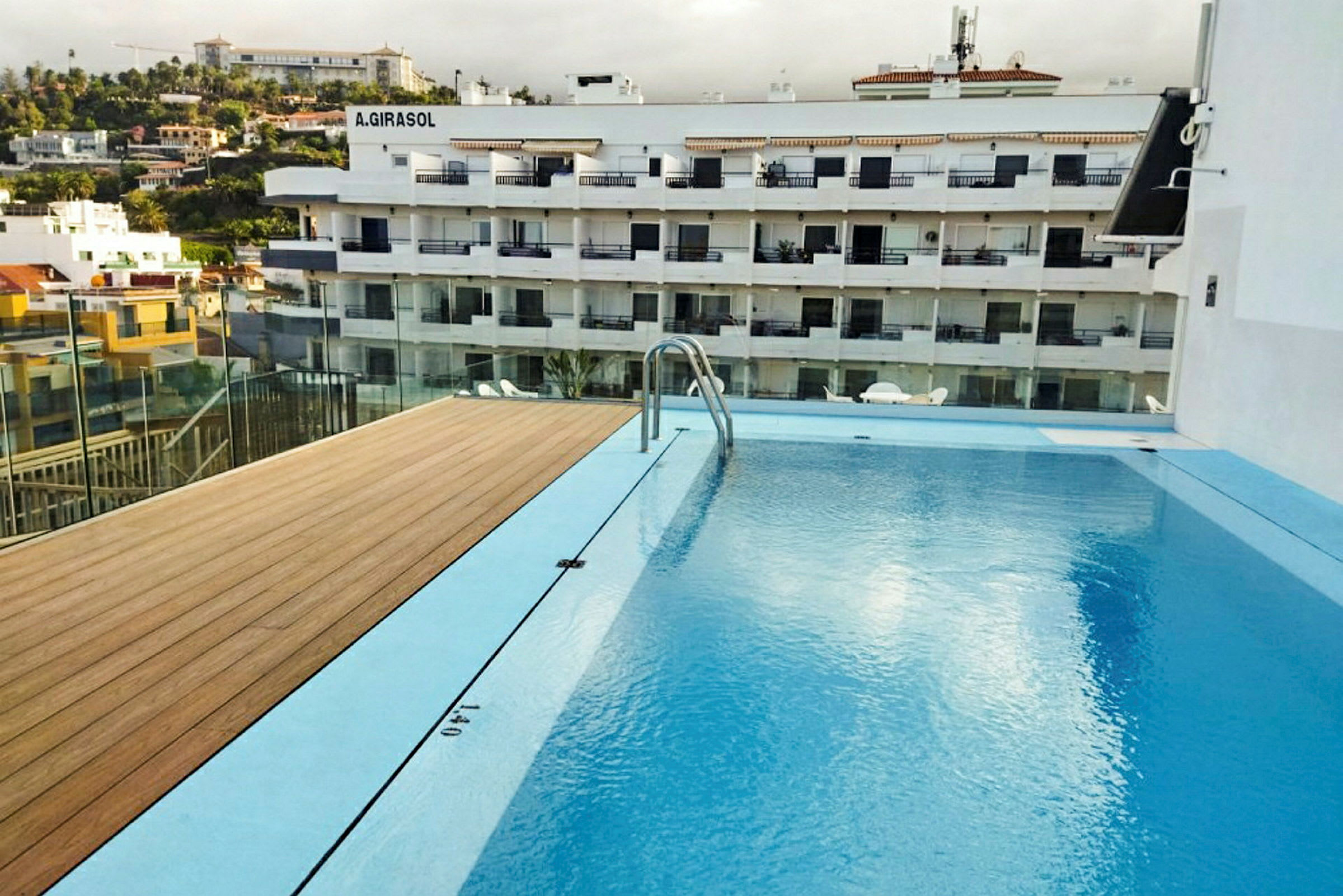 Billede af en swimmingpool med udsigt over en beboelsesejendom i baggrunden. (AI-genereret tekst)