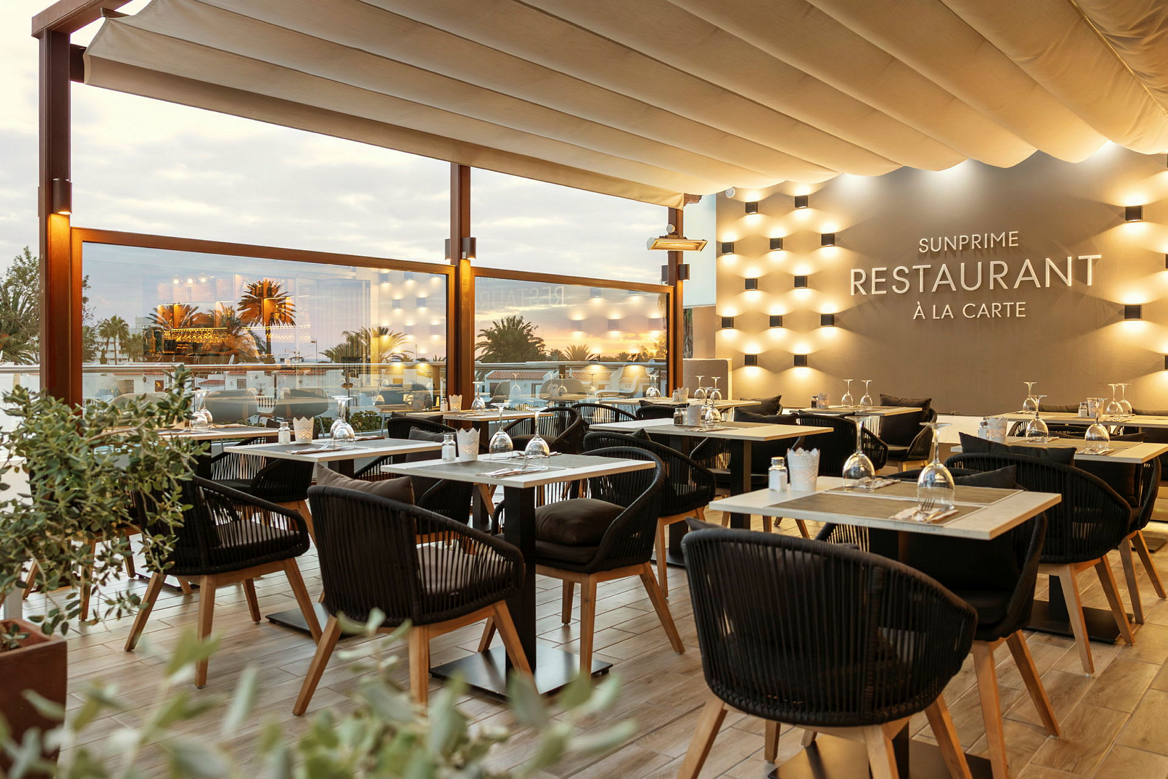 Solbeskinnet restaurantmiljø med elegant oppsatte borde og stole. (AI-genereret tekst)