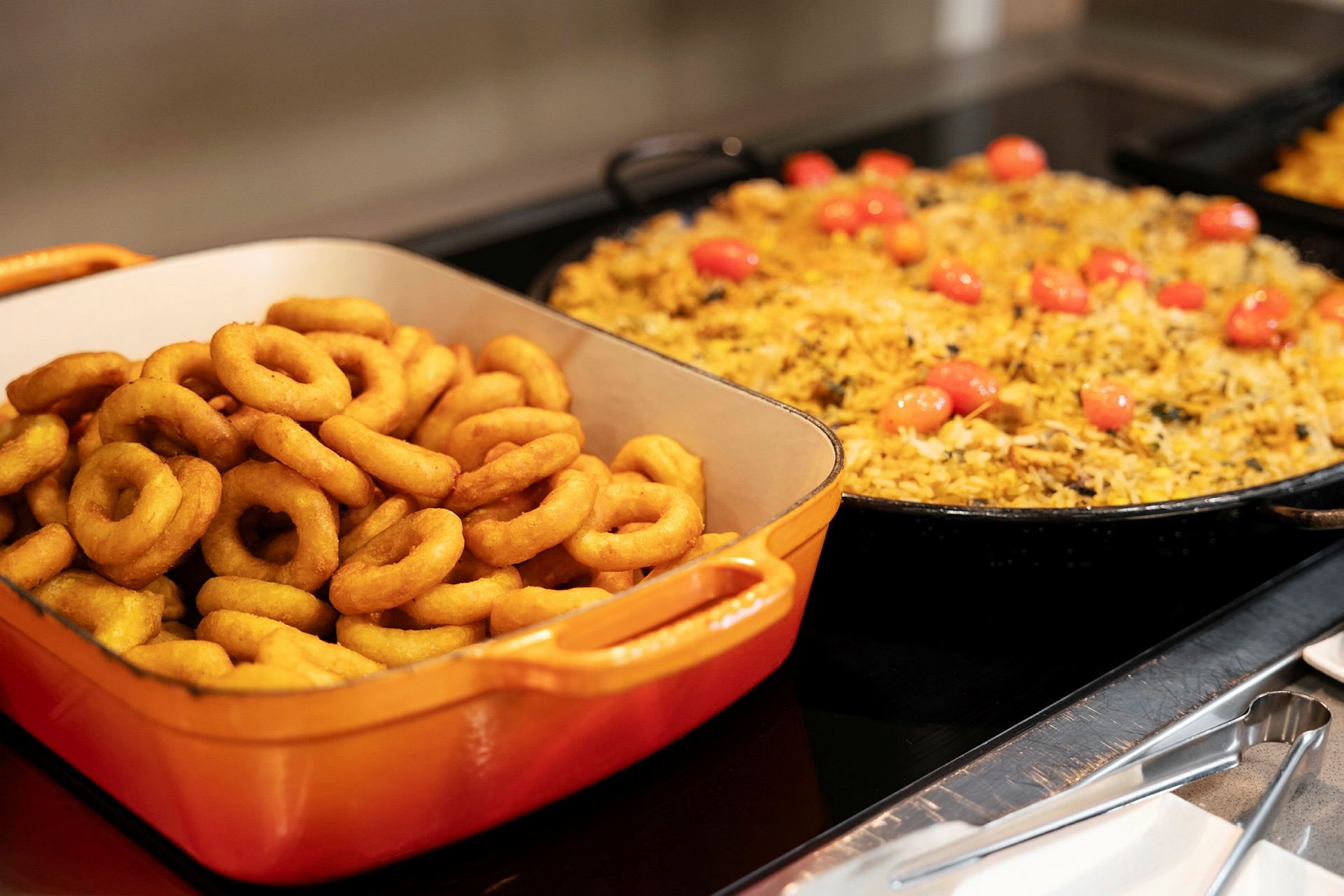 Et billede af en buffet med løgringe og gul risret. (AI-genereret tekst)