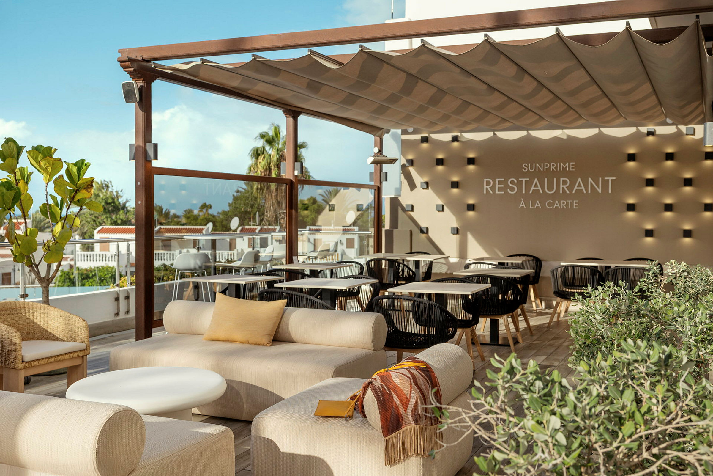 Et udendørsområde med siddepladser og beskyttende tag, med synlig tekst, der viser restaurantens navn. (AI-genereret tekst)