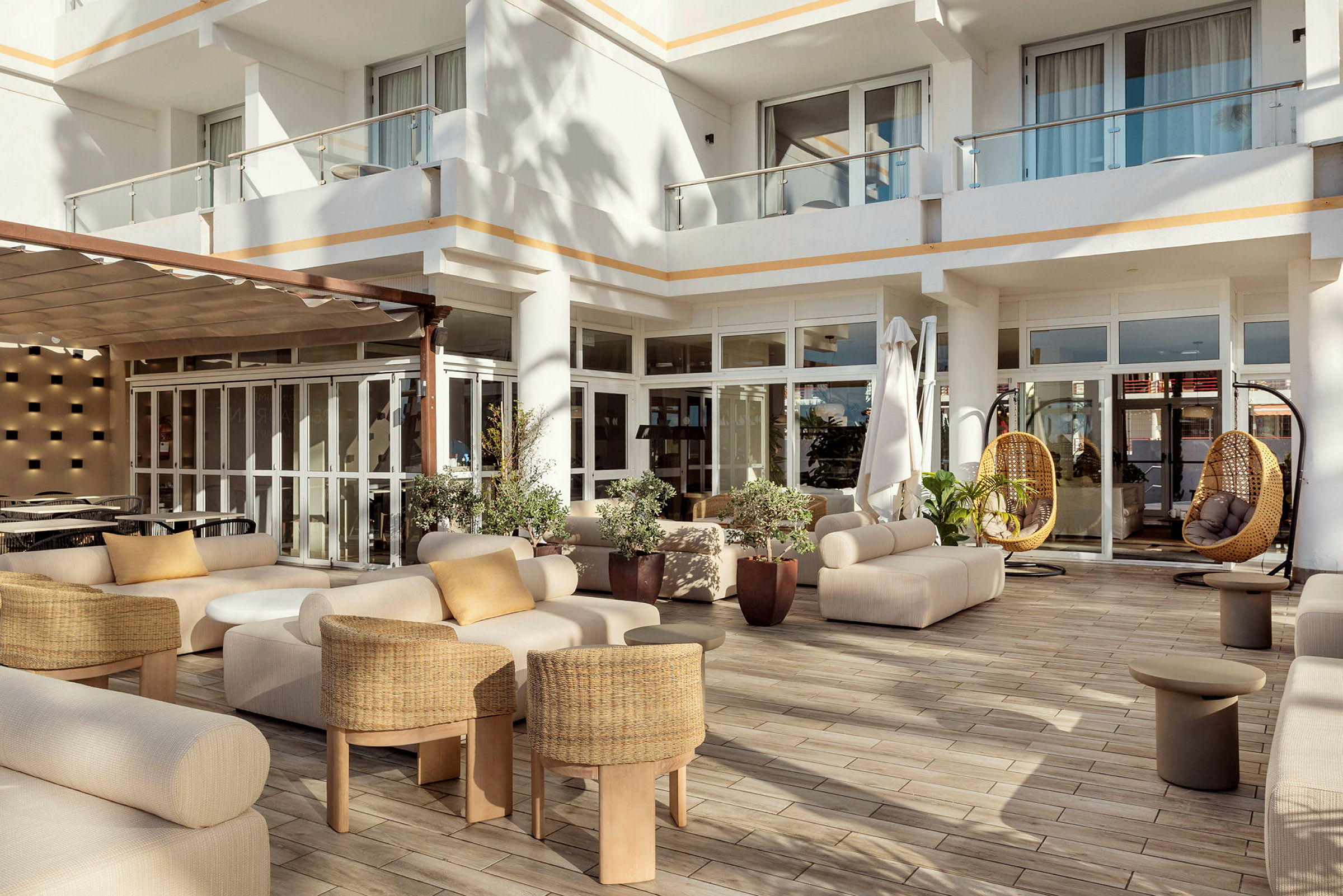 En moderne terrasse med sofaer, små borde og hængestole i stilfuldt design. (AI-genereret tekst)