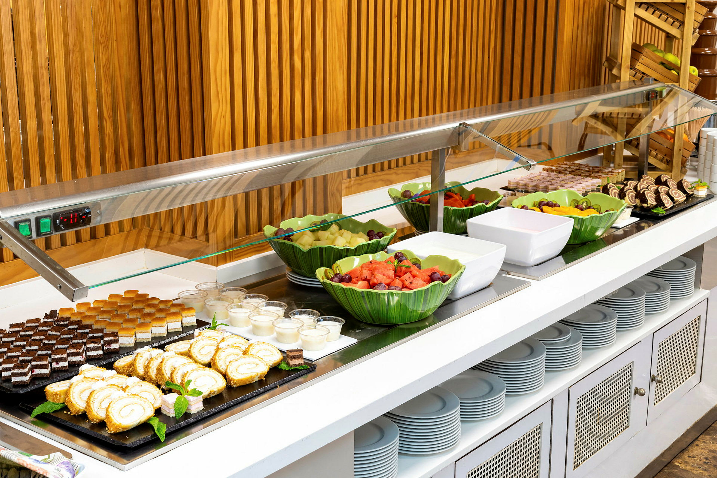 Buffetbord med forskellige desserter og frugtskåle. (AI-genereret tekst)