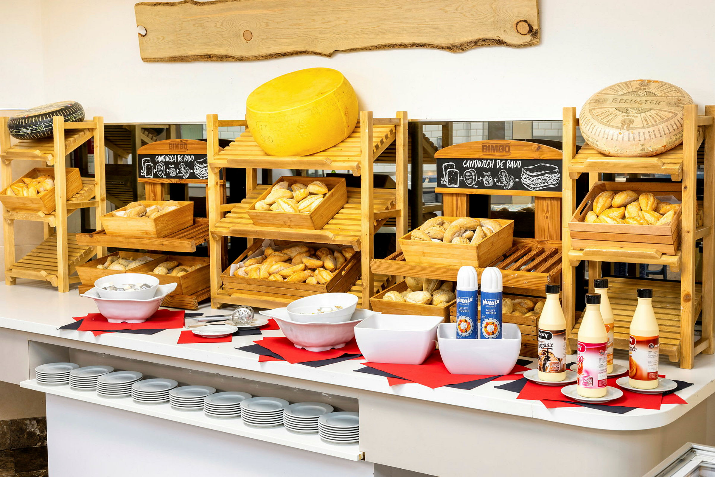 En buffet med brød, ost og saucer på bordet. (AI-genereret tekst)