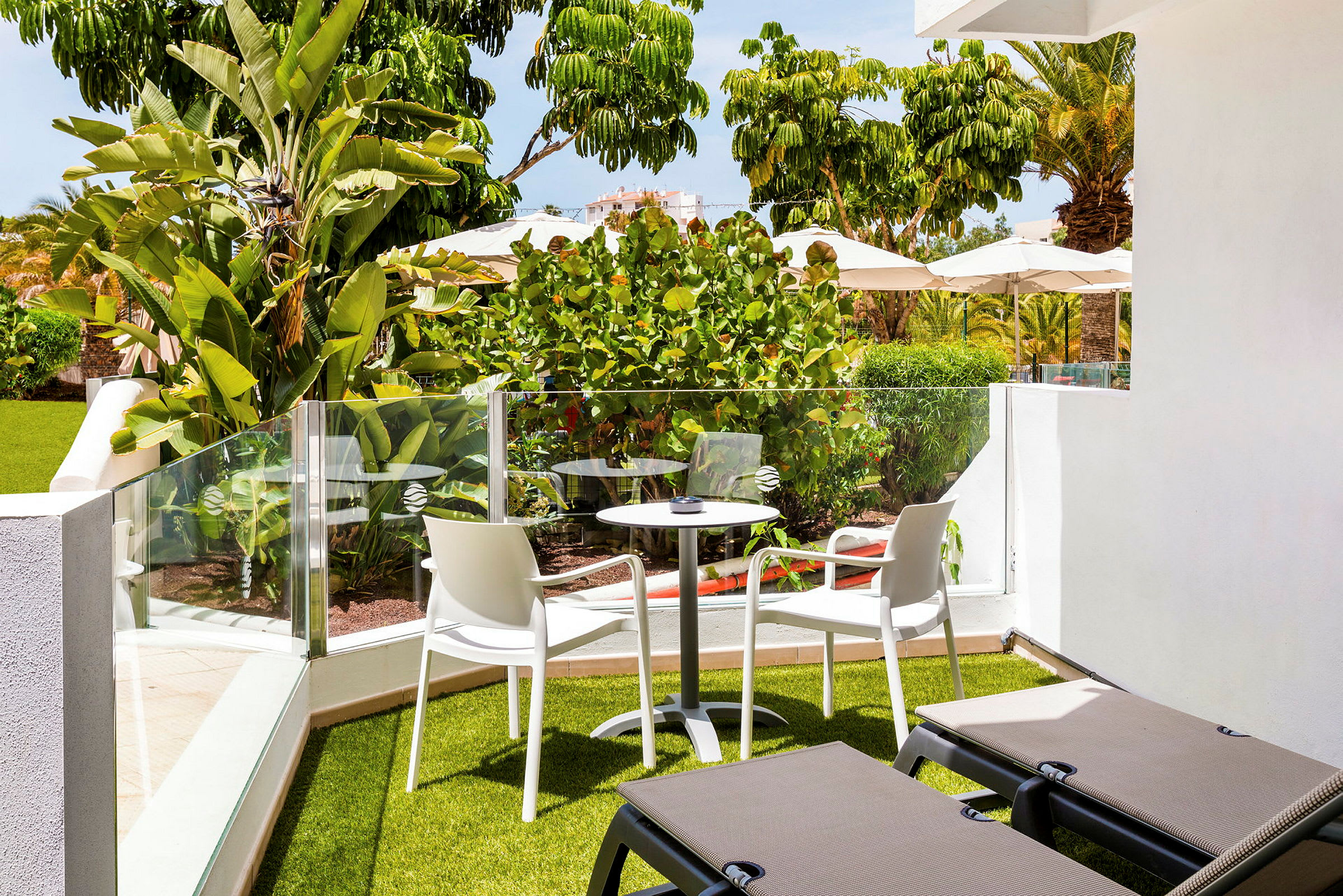 Have terrasse med beplantning, udendørsmøbler og liggestole. (AI-genereret tekst)