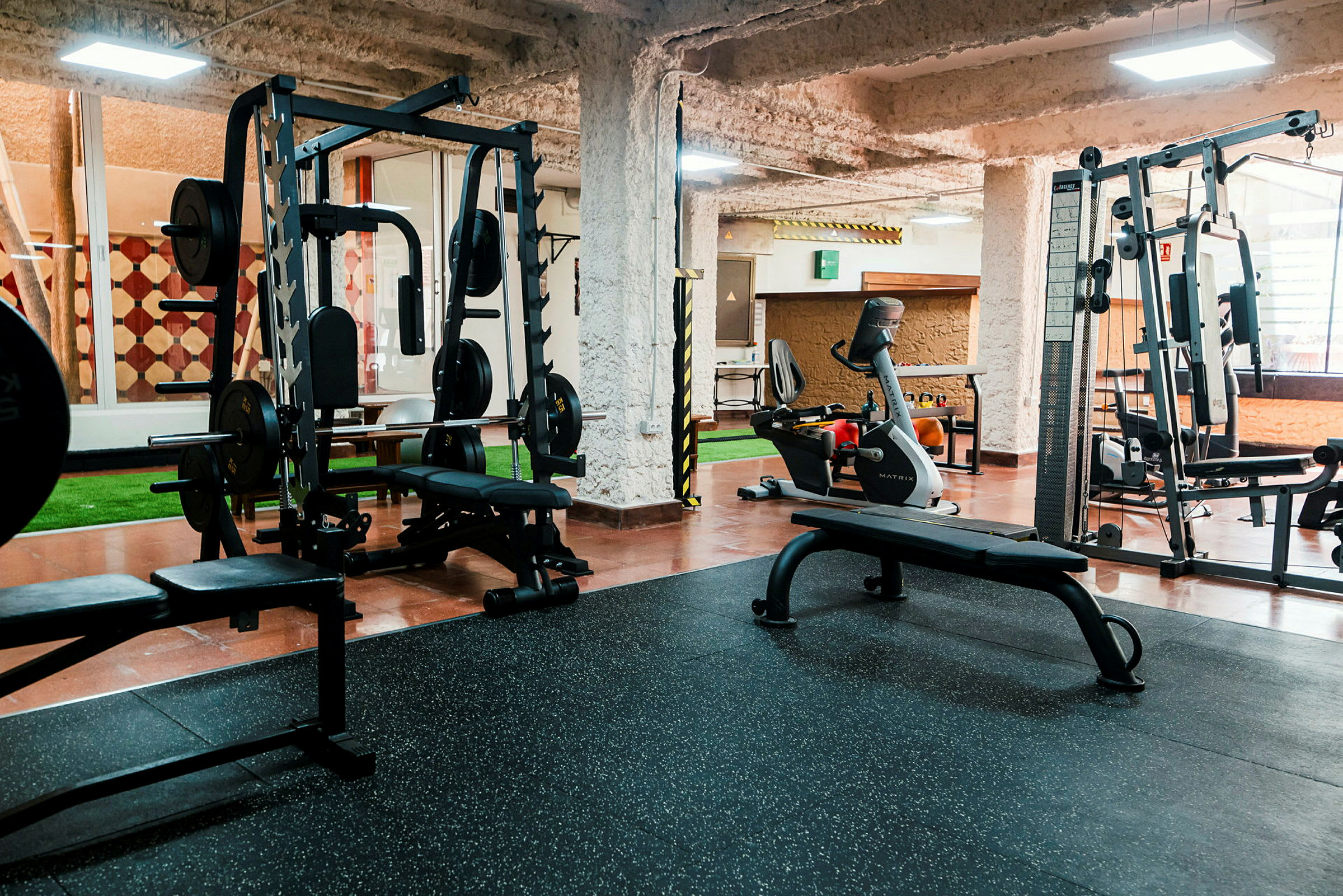 Fitnessrum med træningsmaskiner og bænke. (AI-genereret tekst)
