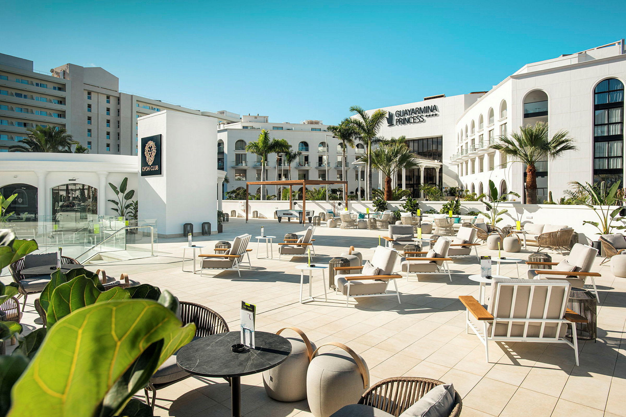 Billede af en udendørsterrasse ved Guayarmina Princess hotellet med liggestole og moderne indretning. (AI-genereret tekst)