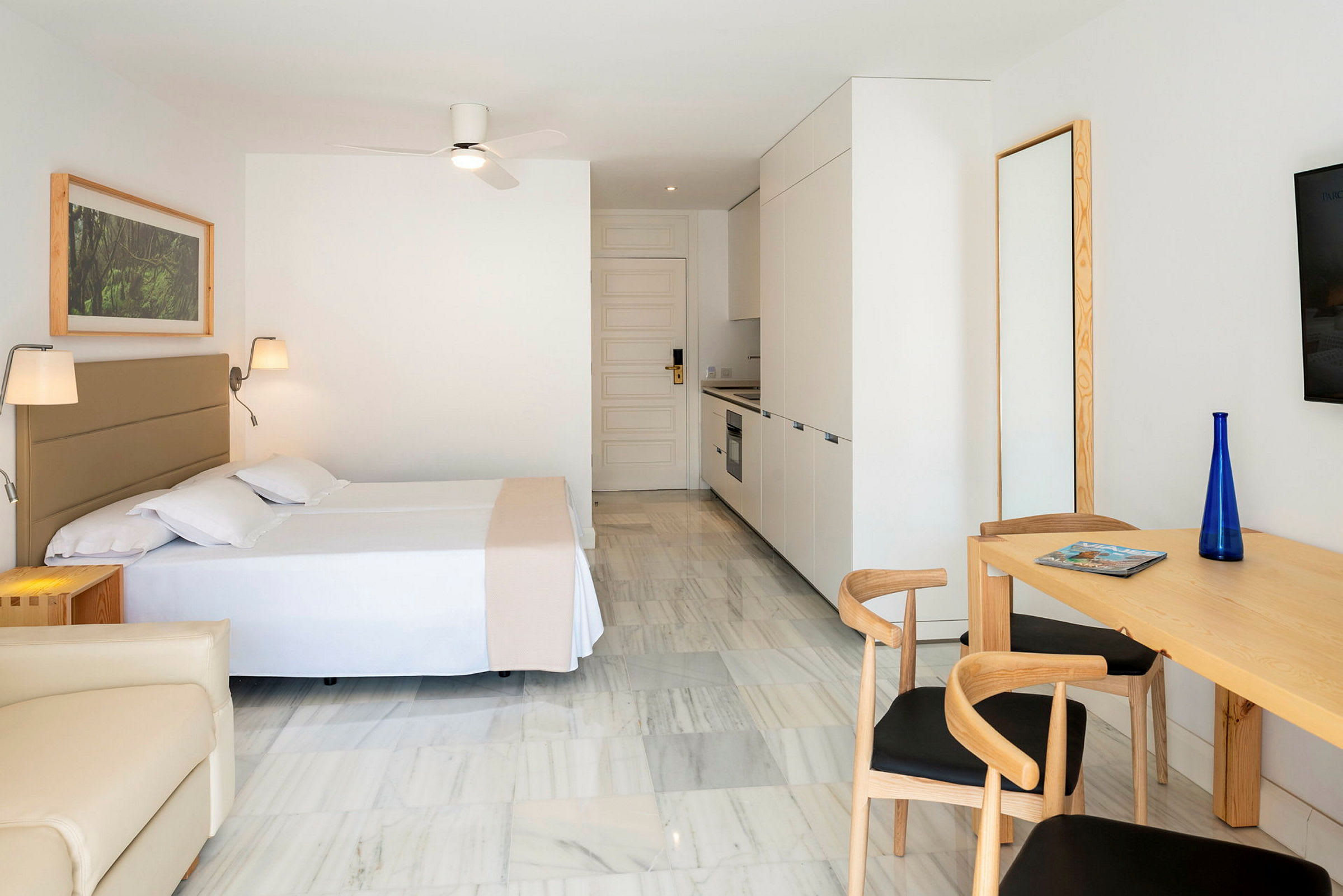 Moderne indrettet hotelværelse med køkkenafdeling og spisebord. (AI-genereret tekst)