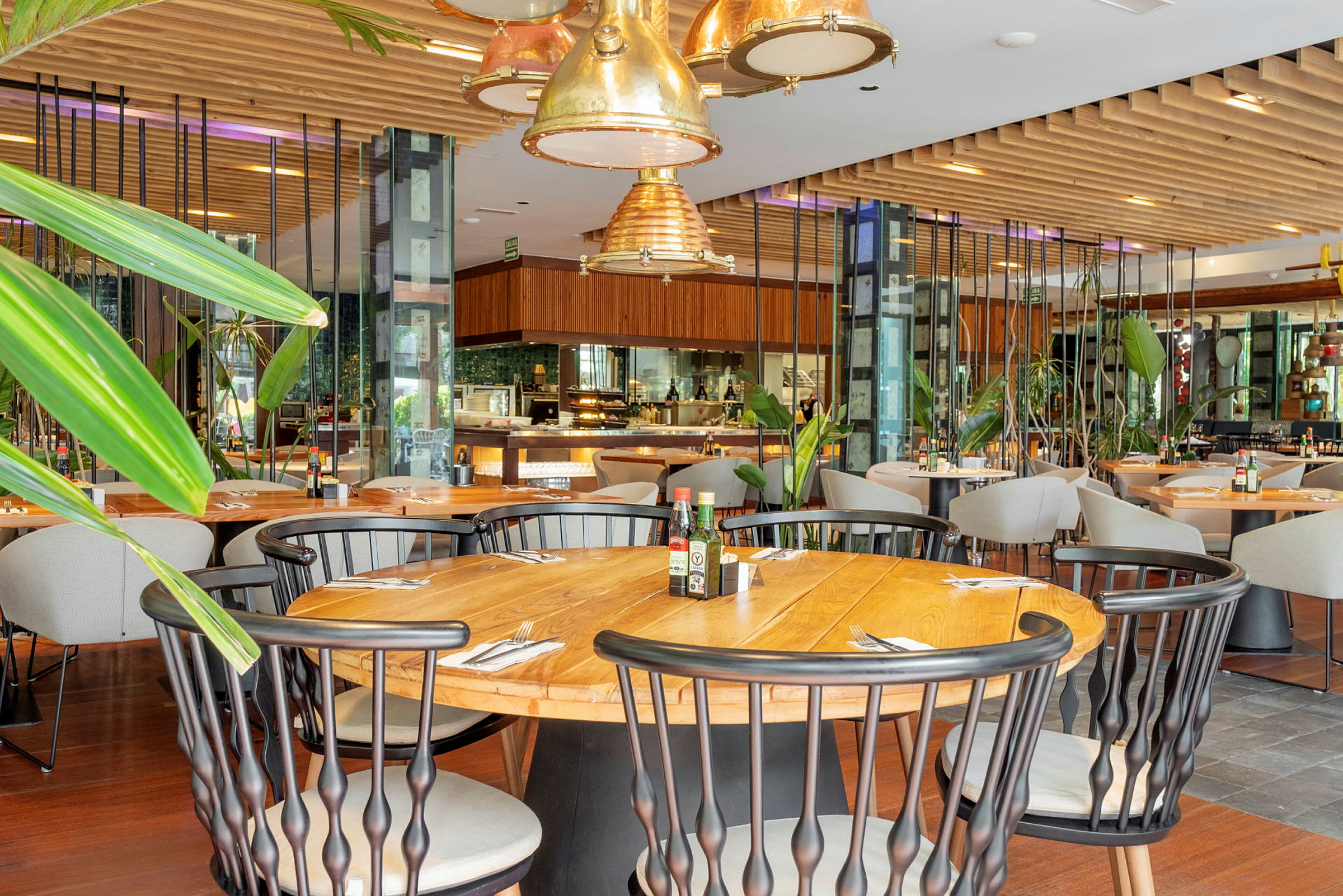 Interiør af en restaurant med træborde, stole og grønne dekorationer. (AI-genereret tekst)