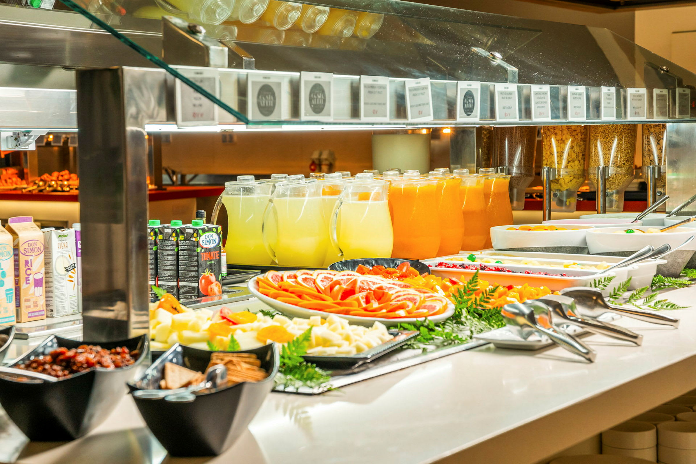 En buffet med forskellige retter, frugt og drikkevarer på en serveringsdisk. (AI-genereret tekst)