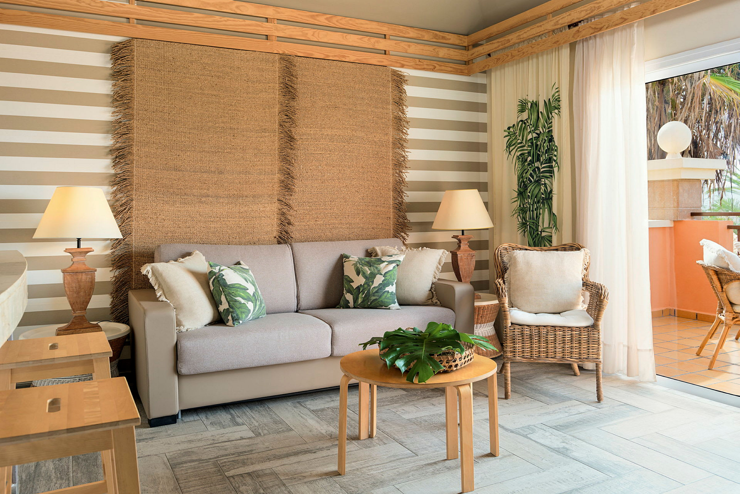 Et stueområde med en sofa, kurvestole og et bord med planter. Gardiner lukker lys ind fra en altan. (AI-genereret tekst)