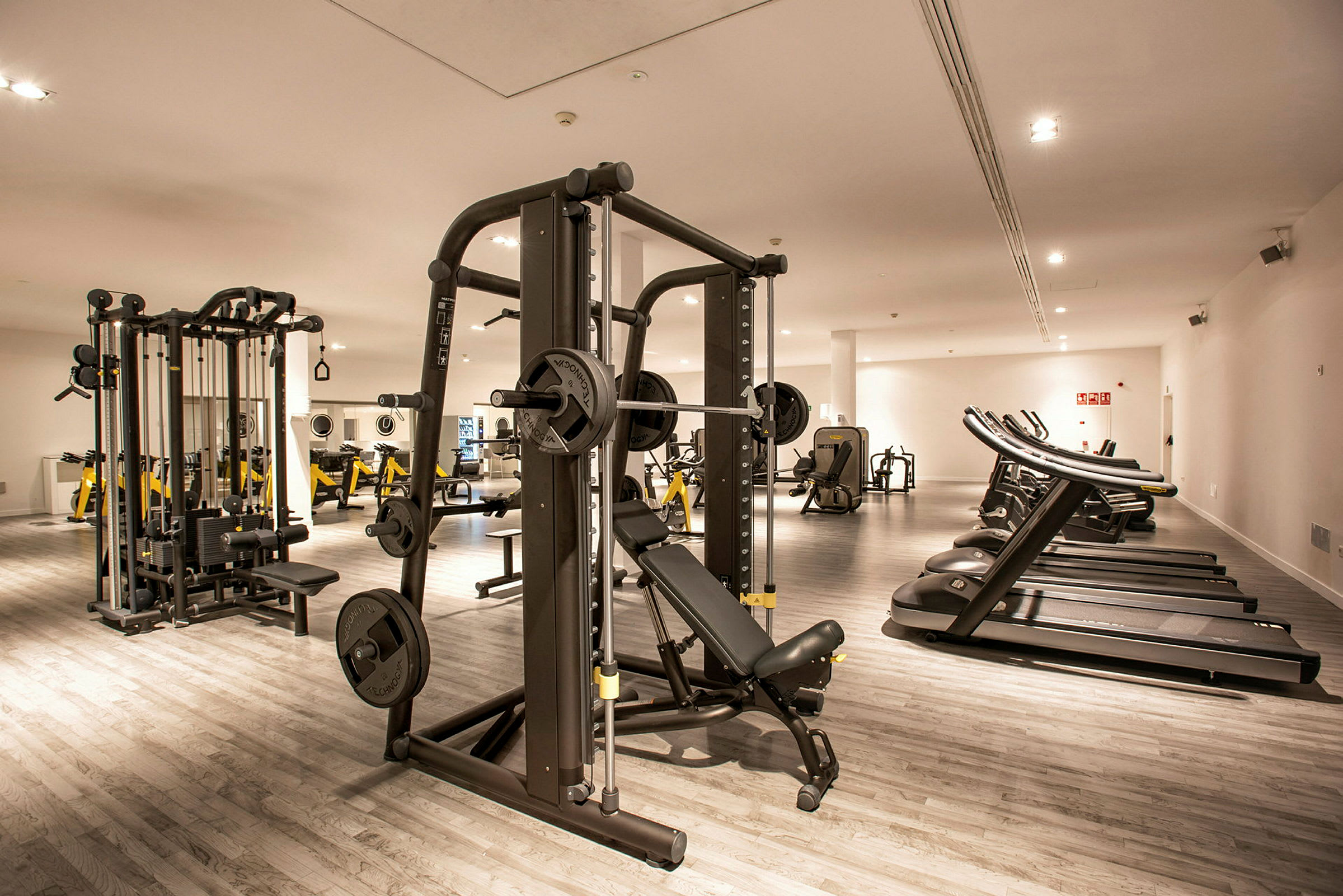 Et fitnesscenter med træningsmaskiner og løbebånd. (AI-genereret tekst)