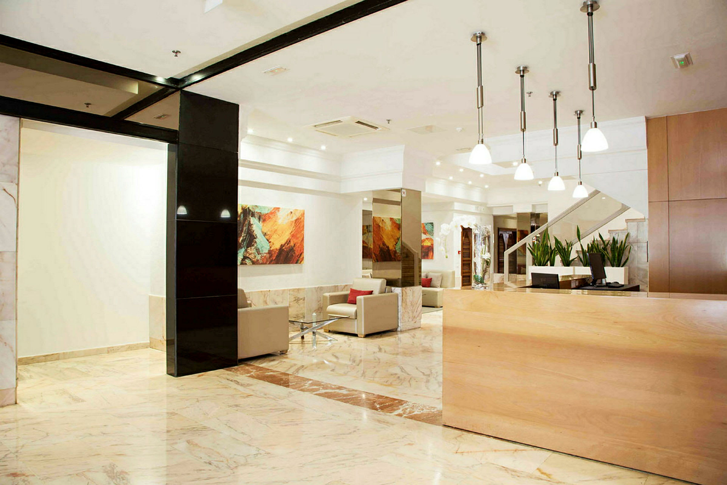 Hotellets lobby med receptionsskranke, siddepladser og dekorationer. (AI-genereret tekst)