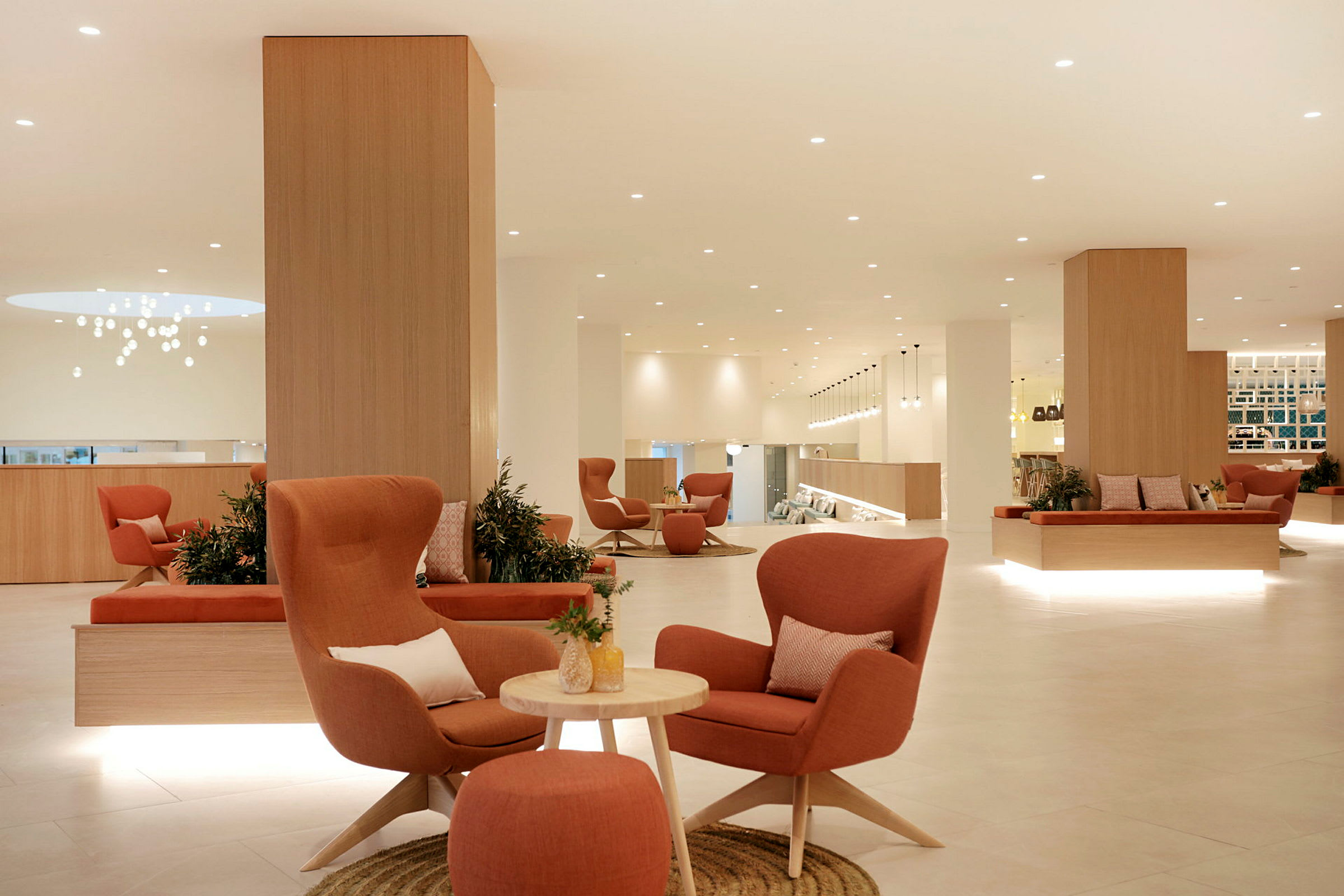 Interiør af en moderne og lys lobby med komfortable stole og borde placeret rundt omkring. (AI-genereret tekst)