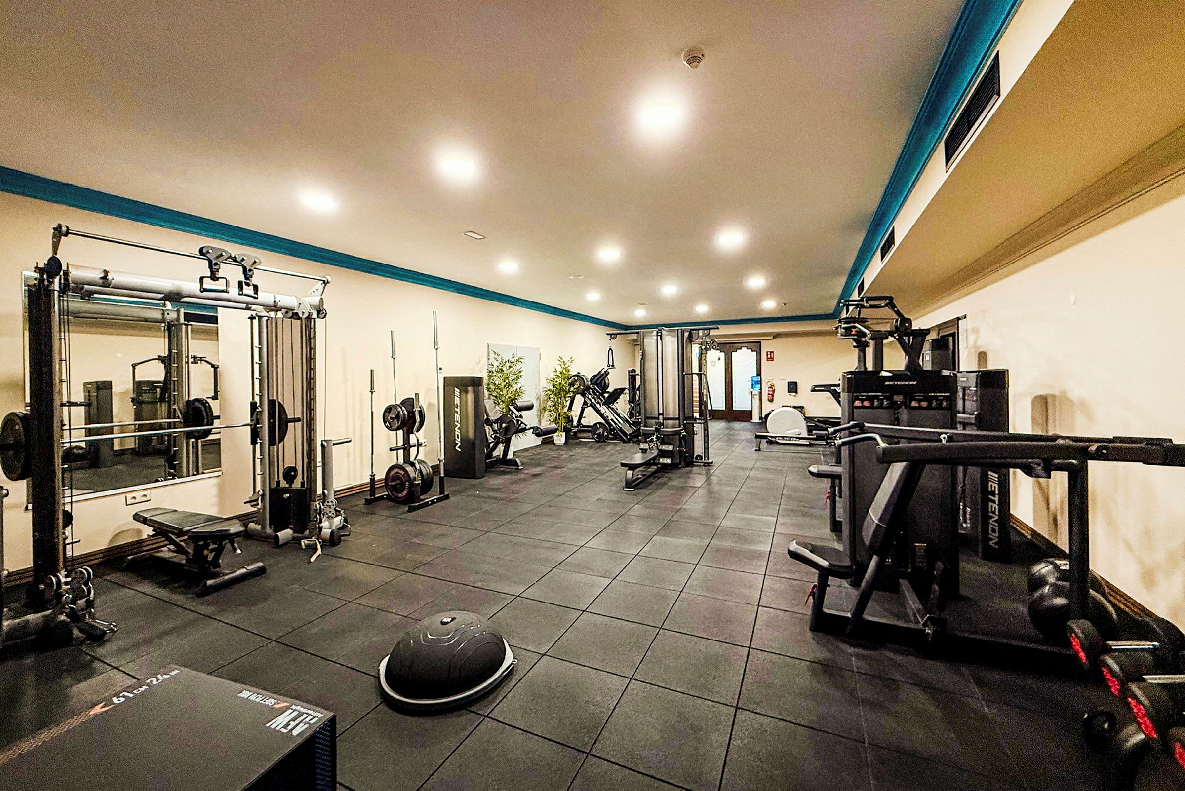 Fitnesscenter med træningsudstyr og belysning. (AI-genereret tekst)