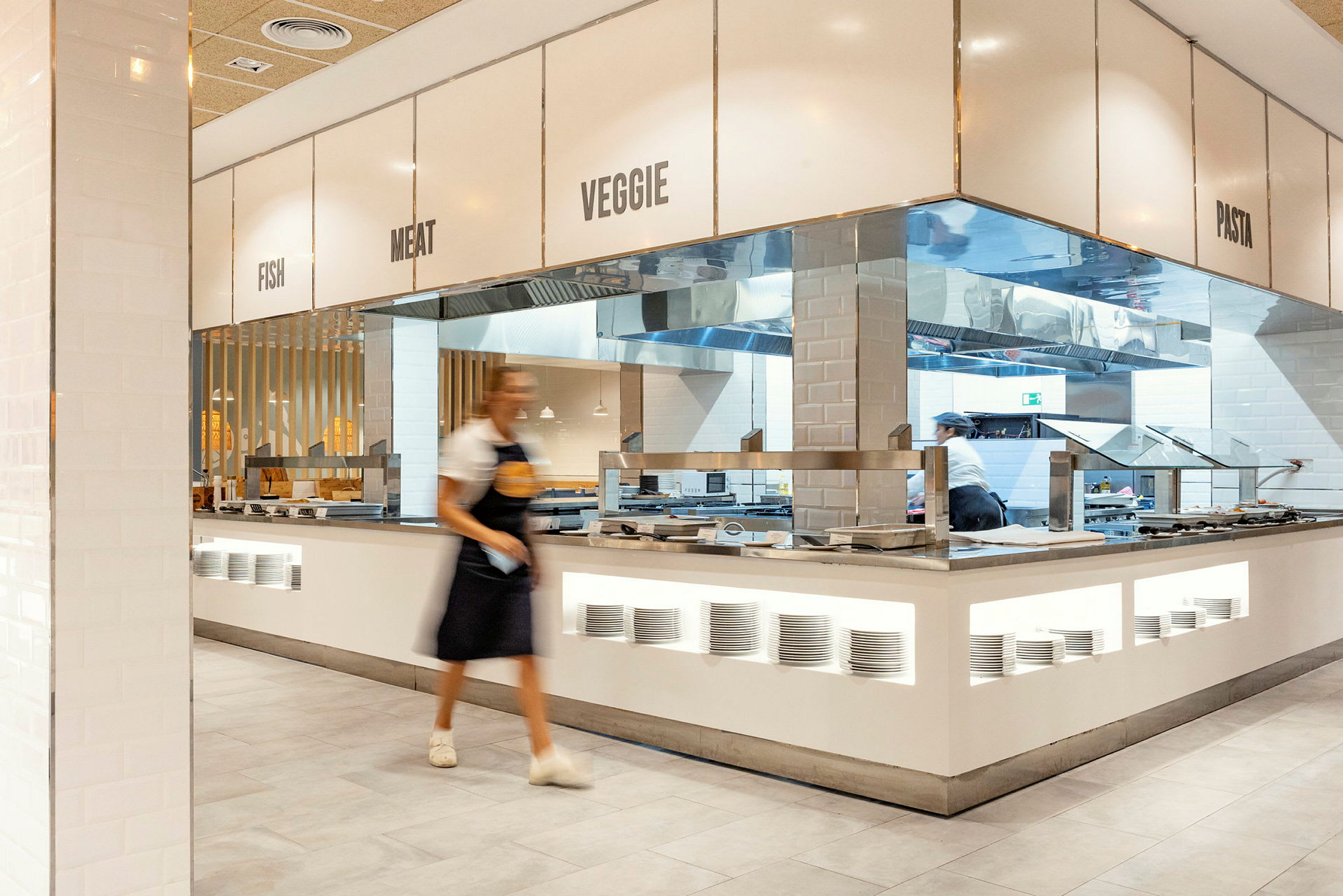 Buffetområde med forskellige madstationer. Skiltet angiver kategorier som fisk, kød, vegetarisk og pasta. (AI-genereret tekst)