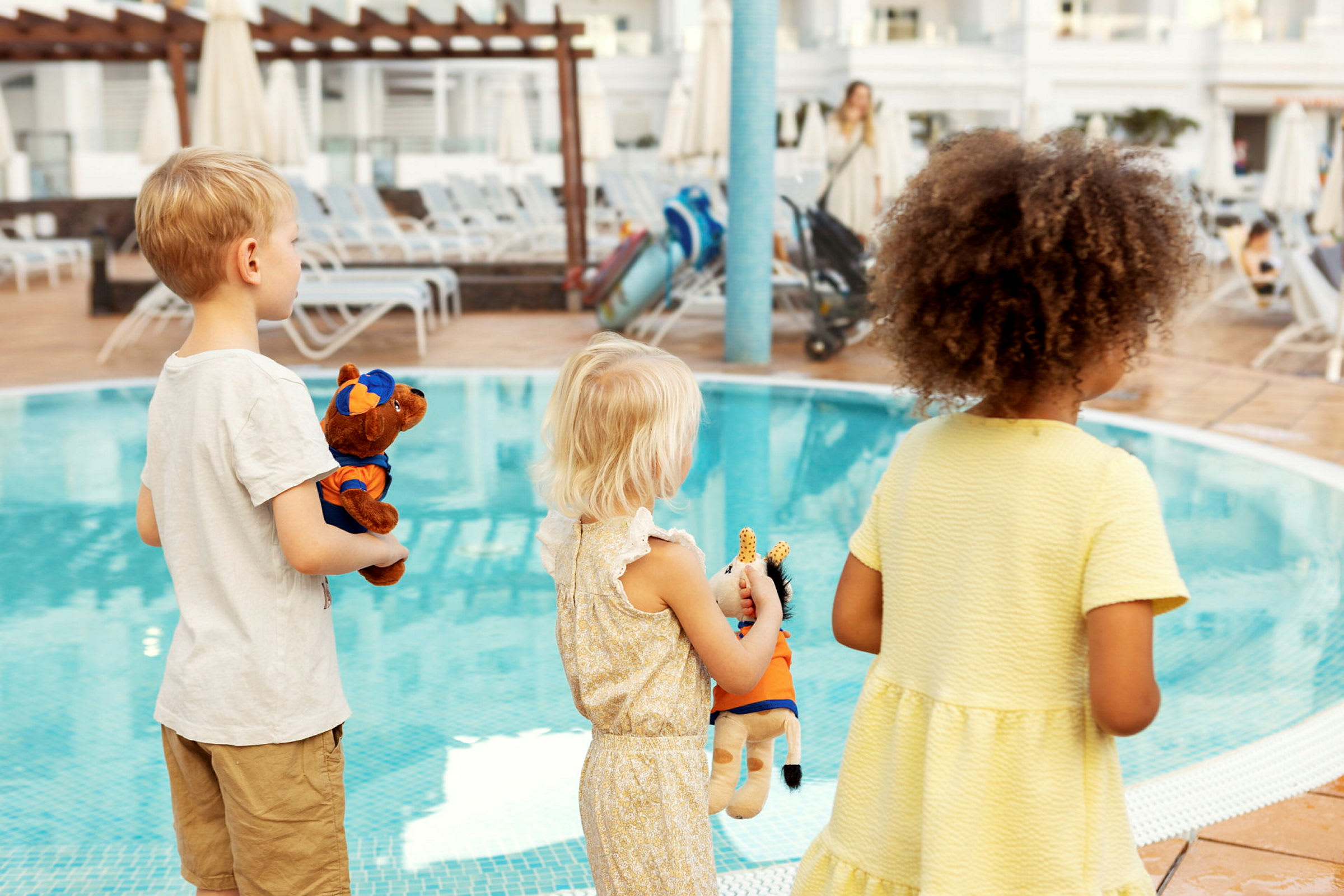 Børn står ved en pool og holder tøjdyr. (AI-genereret tekst)