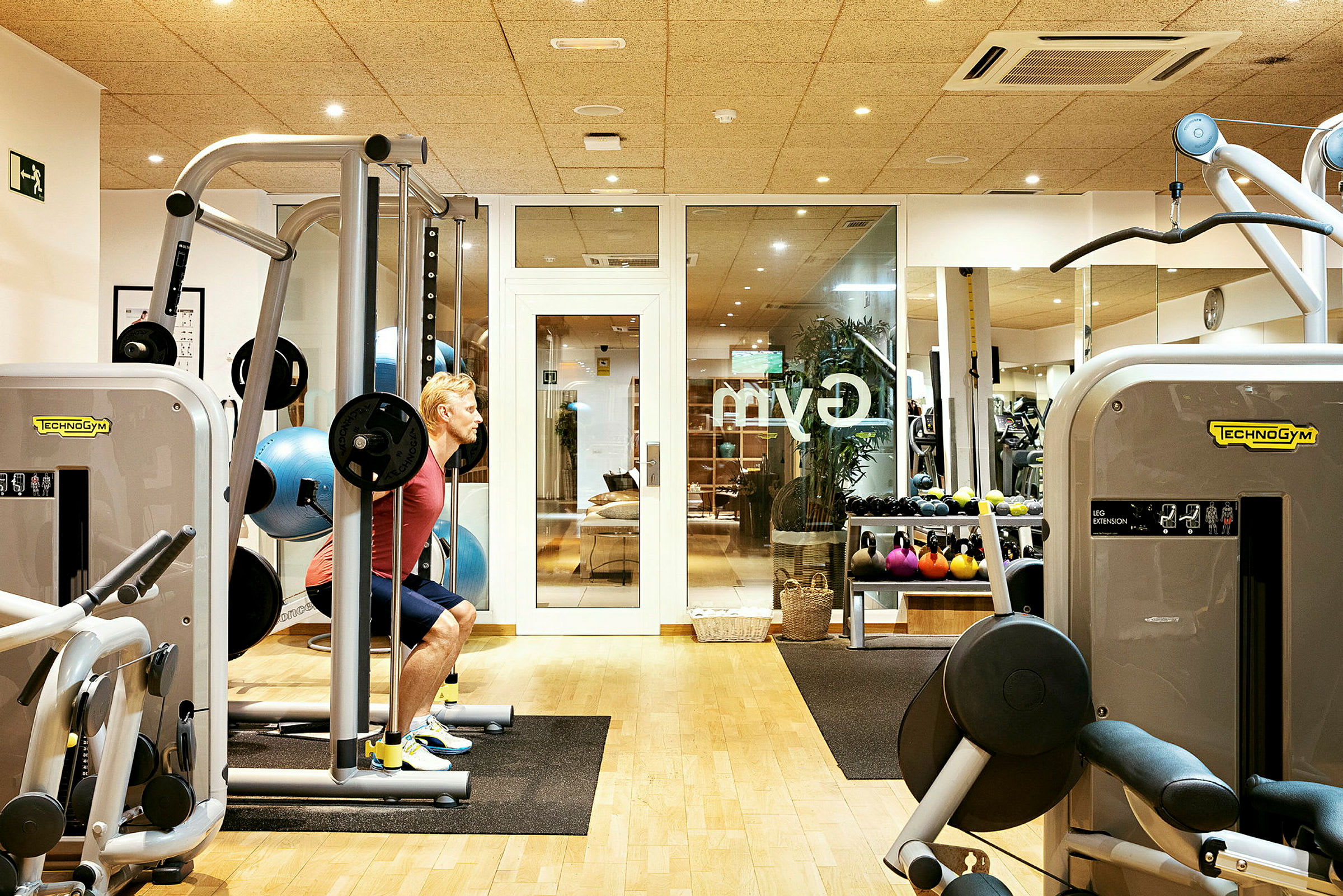 Et træningscenter med fitnessmaskiner og vægte. (AI-genereret tekst)