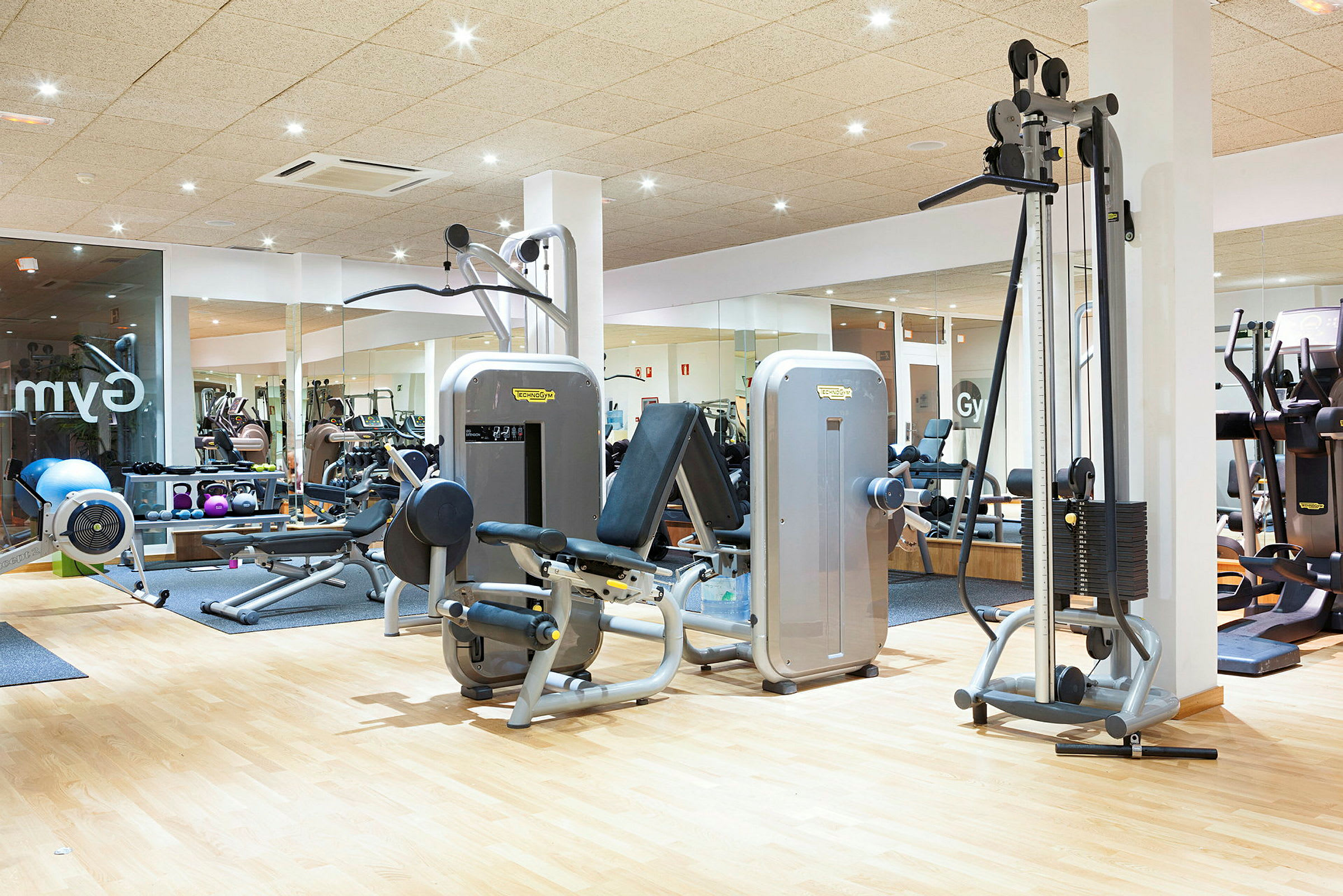 Fitnesscenter med træningsmaskiner og udstyr. (AI-genereret tekst)