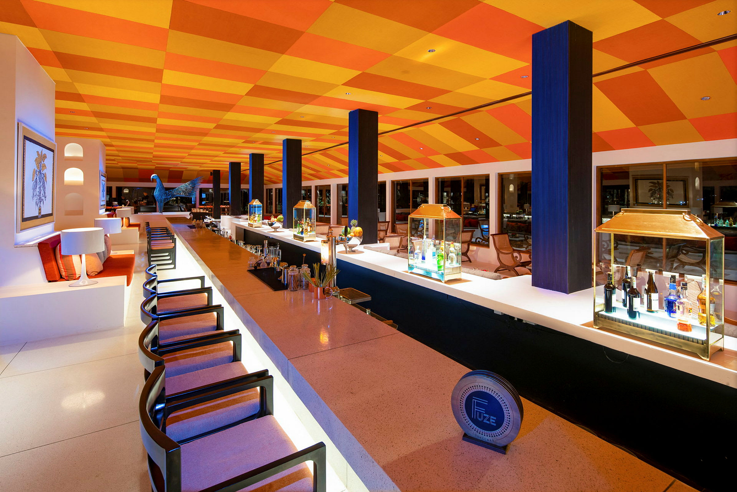 Et billede af en moderne bar med farverigt dekorativt loft, belysning og siddepladser. (AI-genereret tekst)