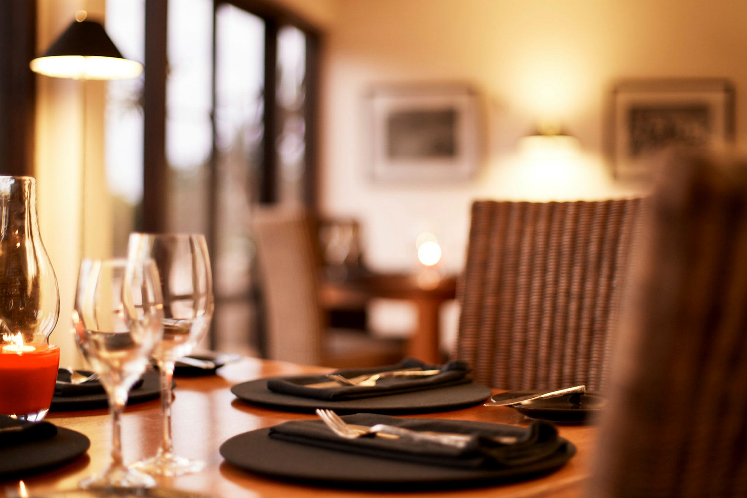 Et billede af et dækket restaurantbord med glas og tallerkener. (AI-genereret tekst)