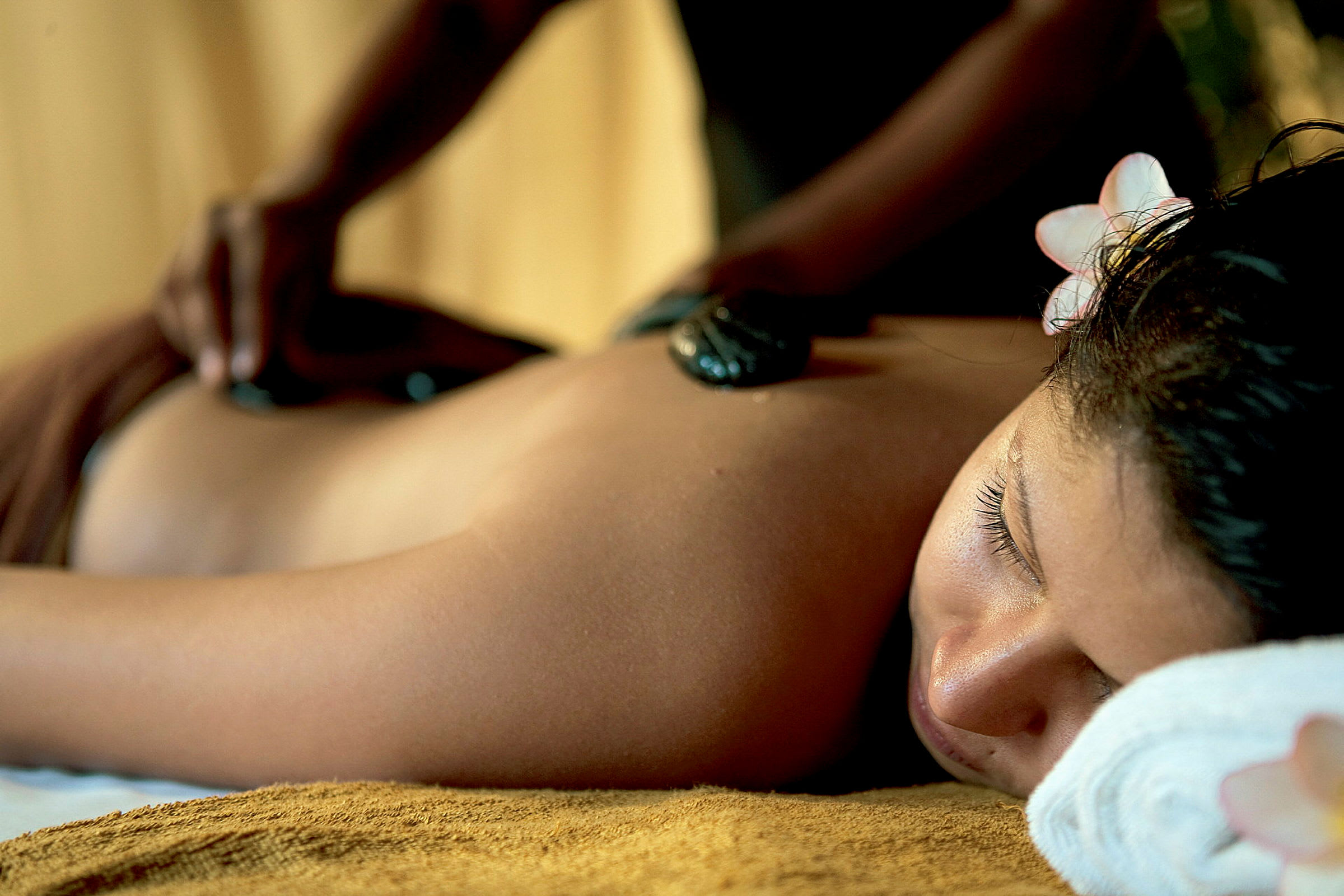 En person får en afslappende massage med varme sten. (AI-genereret tekst)