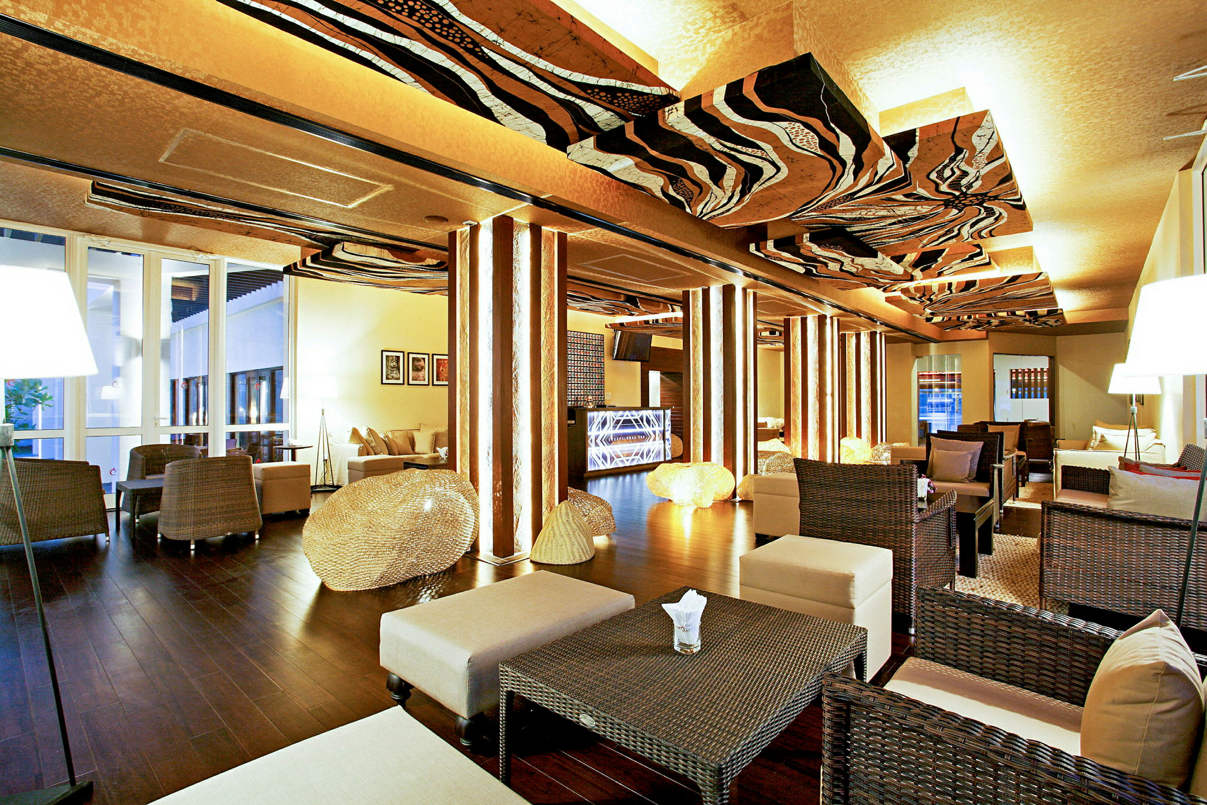 En elegant lounge med moderne indretning, kurvemøbler, borde og belysning pryder rummet. (AI-genereret tekst)