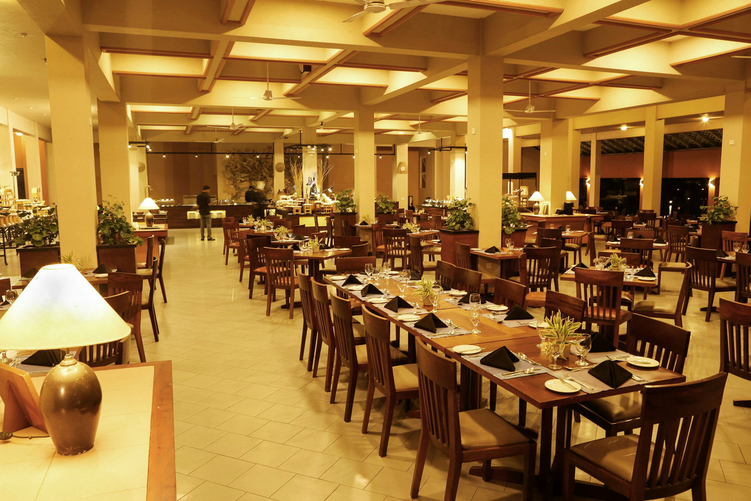 Stort område med en restaurant, borde og stole til gæster samt en buffet i baggrunden. (AI-genereret tekst)