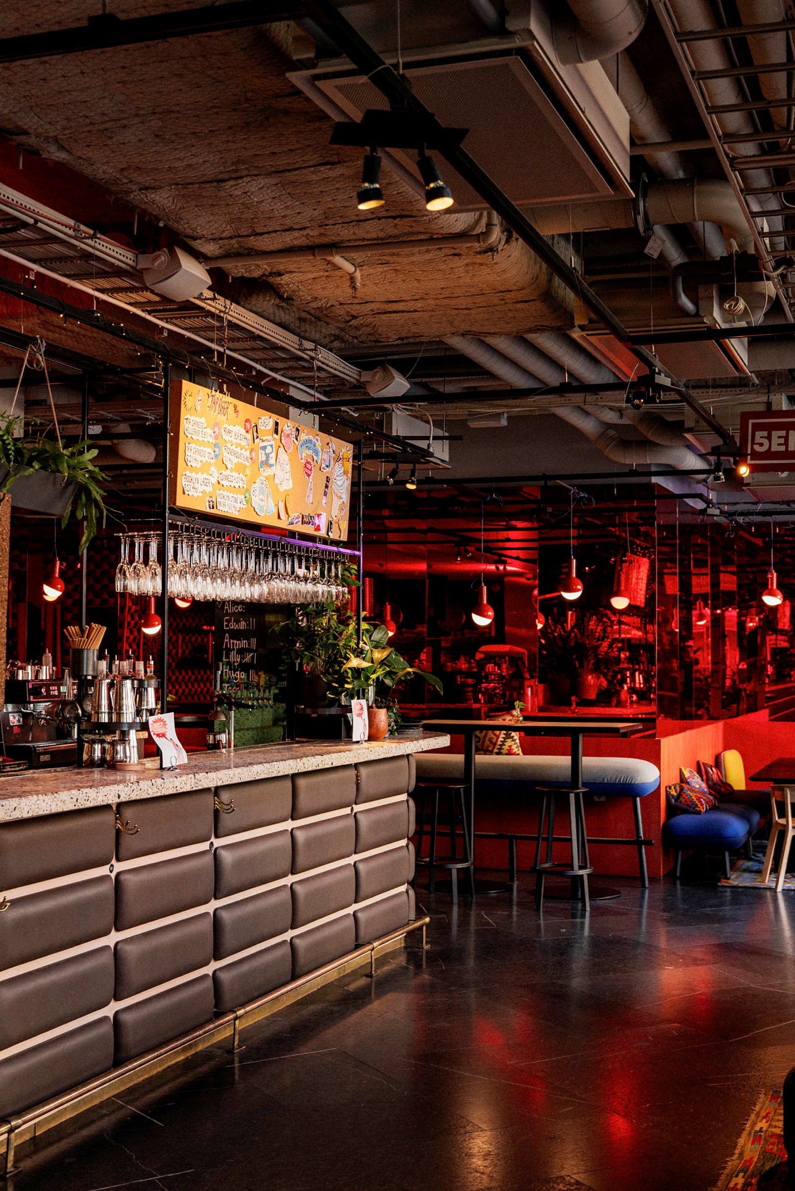 Billede af en moderne bar med en marmoreret bardisk, glas, hængende menu og rødt lys i interiøret. (AI-genereret tekst)