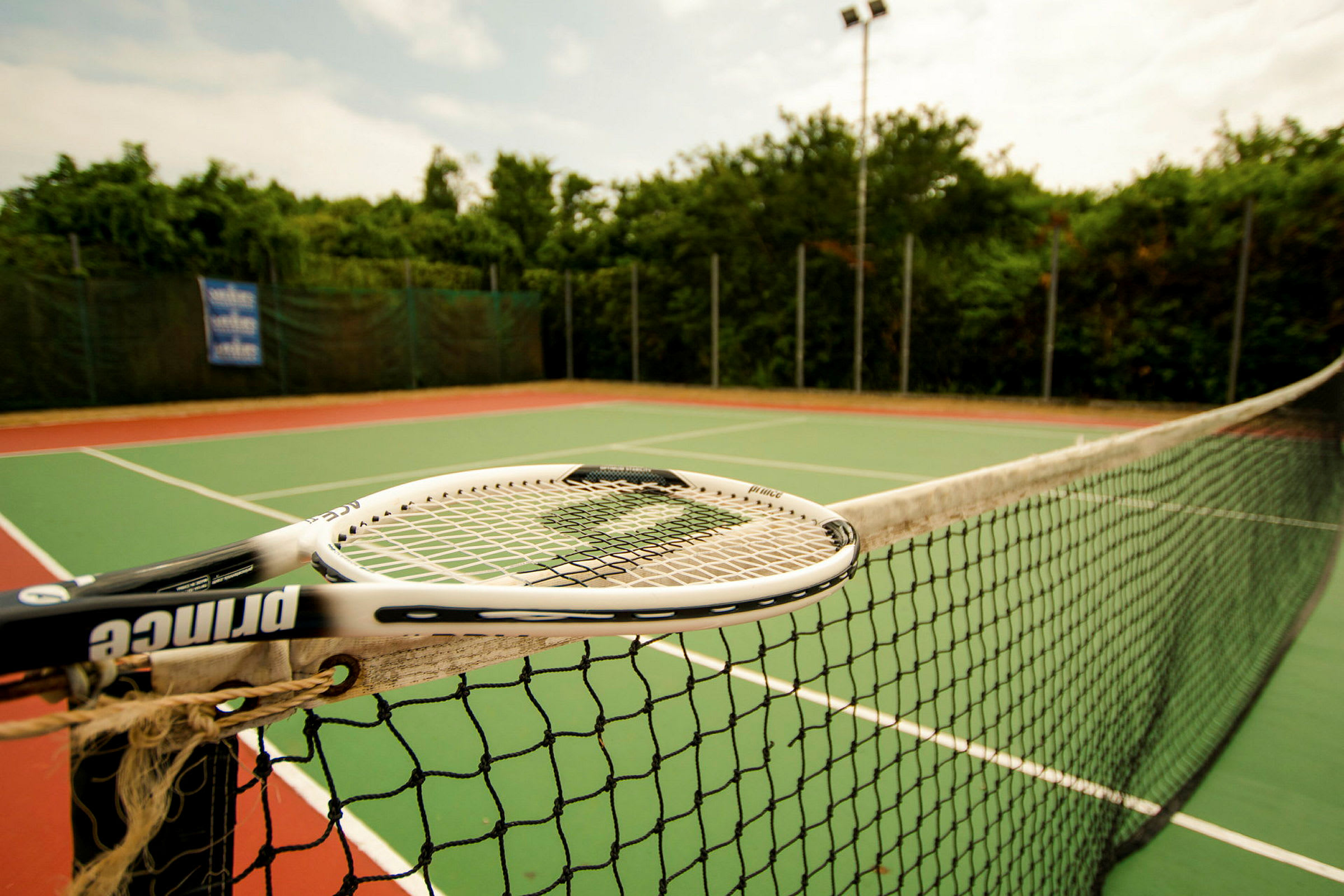 En tennisbane med net og ketsjer. (AI-genereret tekst)