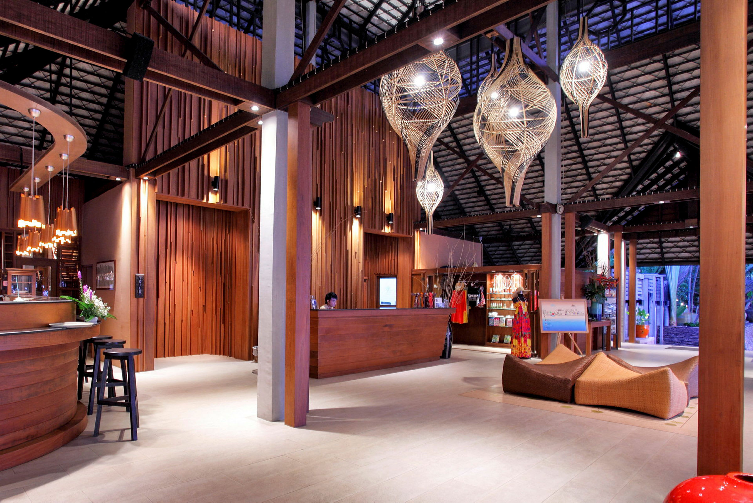 En hotellobby med træinteriør, en reception og dekorative lysarmaturer. (AI-genereret tekst)