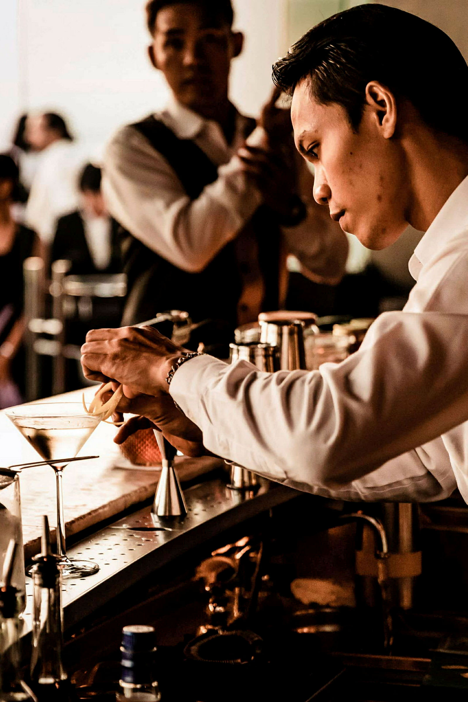 En bartender laver en cocktail ved en bardisk. (AI-genereret tekst)