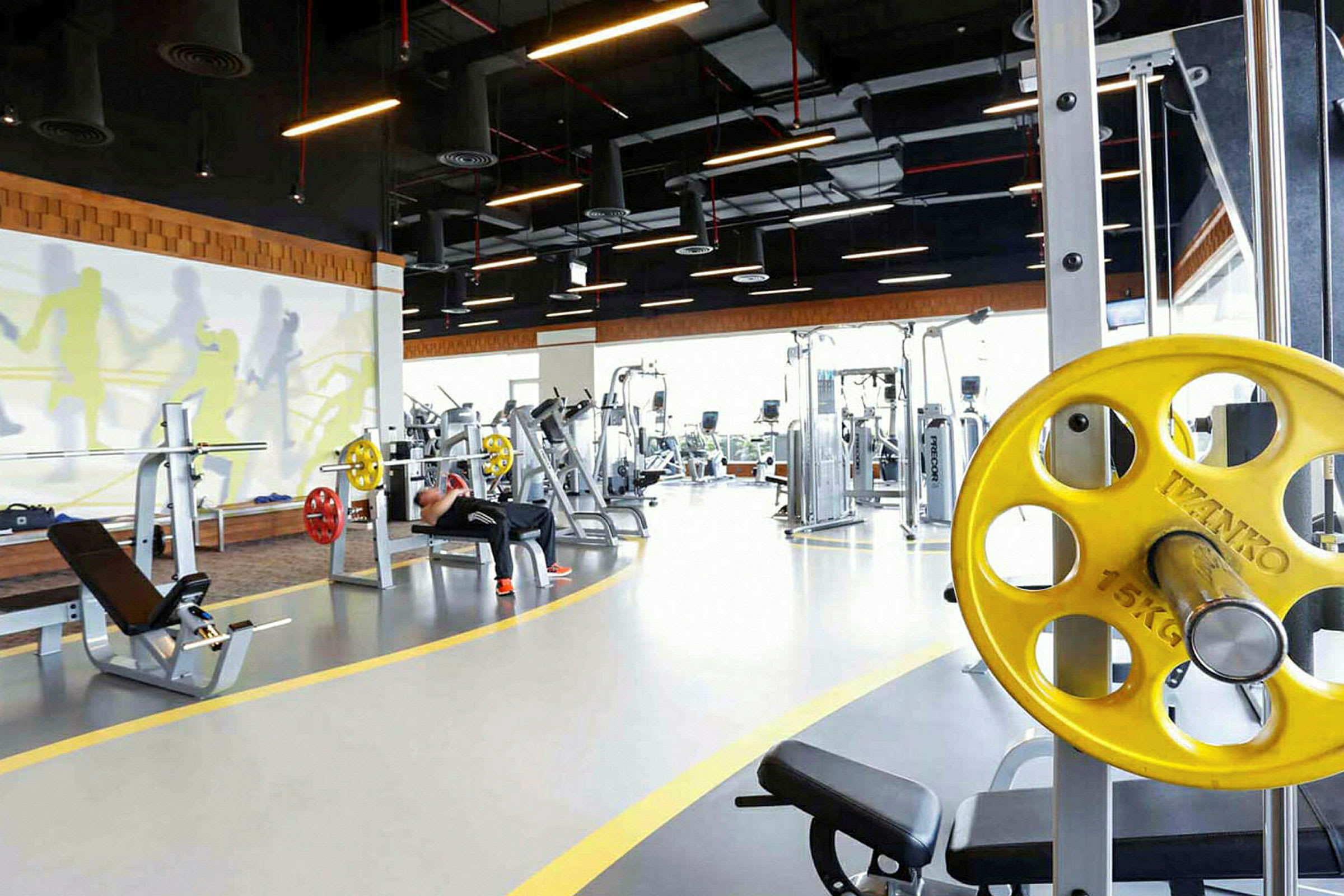 Et fitnesscenter med træningsudstyr og et lyst interiør. (AI-genereret tekst)