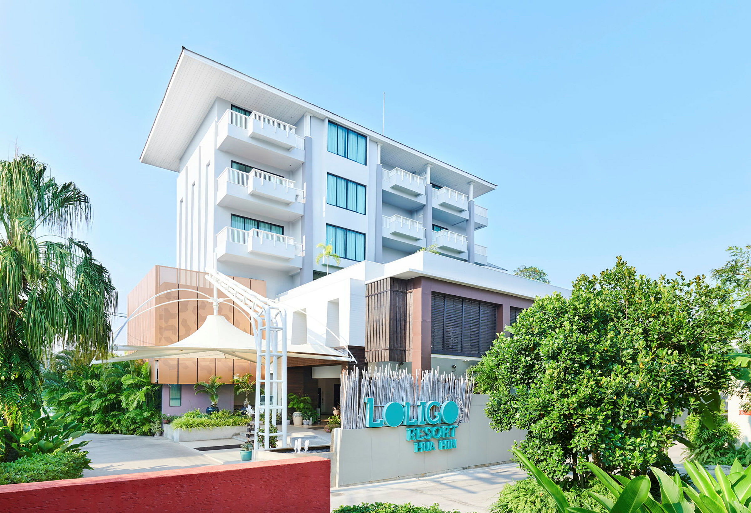 Billede af Loligo Resort Hua Hin med grønne områder og blå himmel. (AI-genereret tekst)