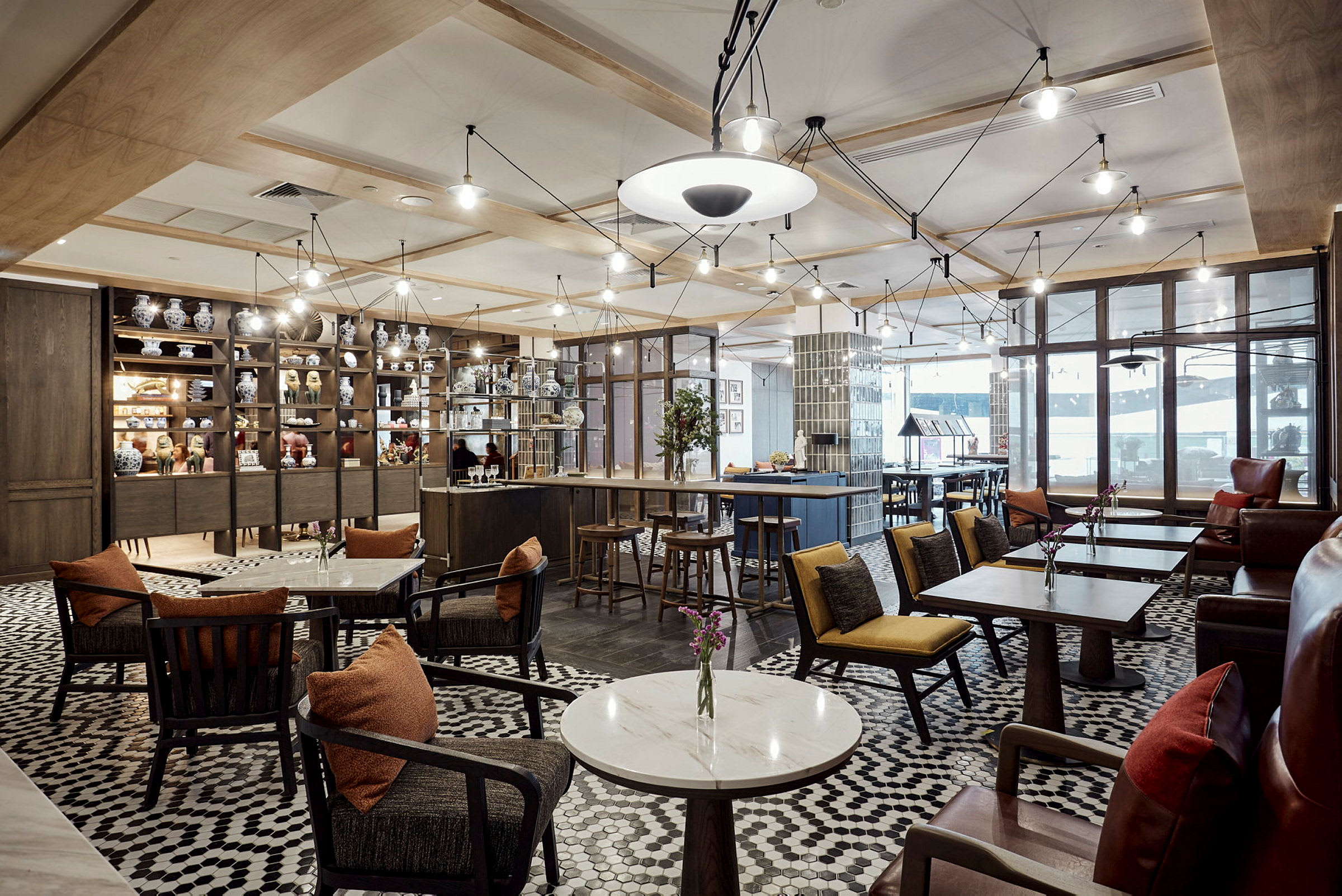 En elegant café med borde og stole, omgivet af hylder med porcelænsfigurer. (AI-genereret tekst)