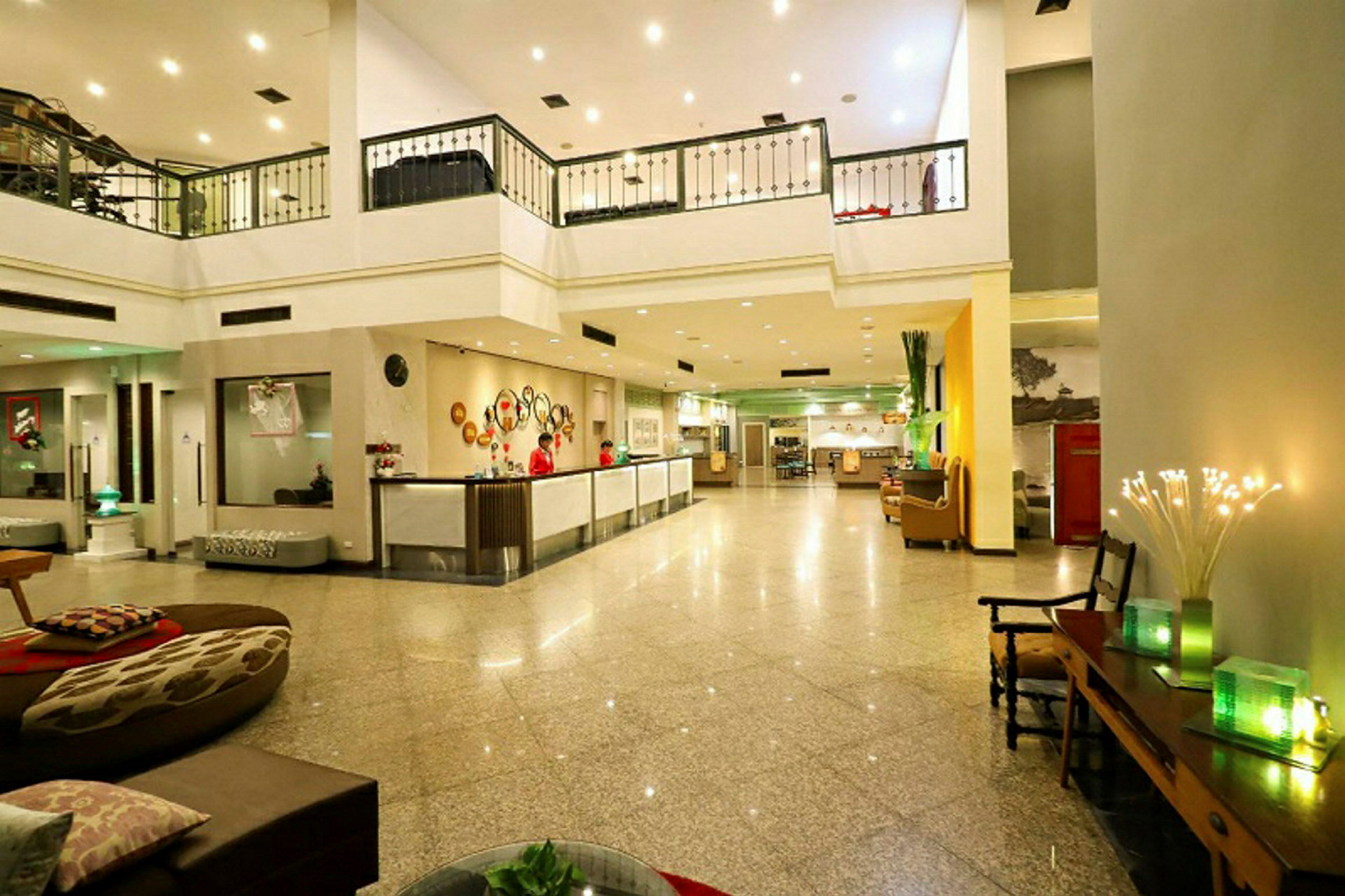 Billede af en hotellobby med reception, siddeområder og dekorationer. (AI-genereret tekst)