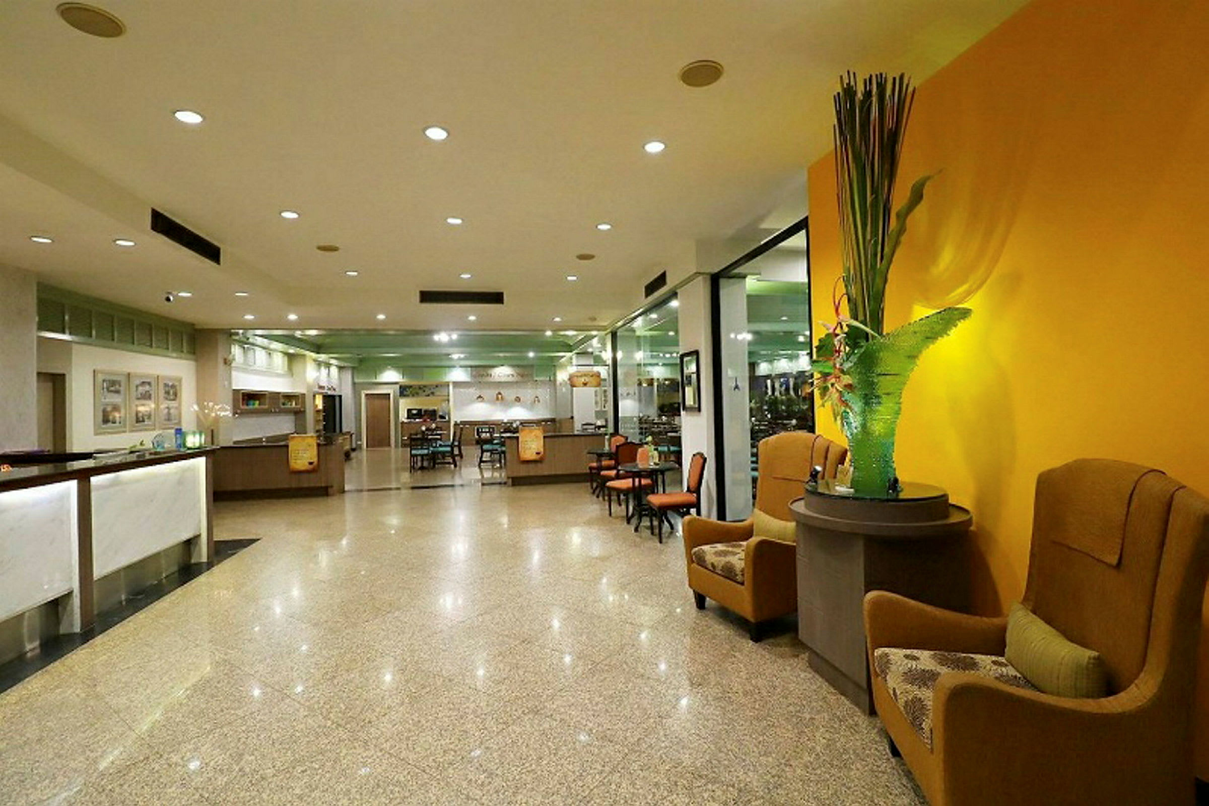 Et moderne hotellets lobbyområde med siddepladser, reception og dekorative elementer. (AI-genereret tekst)