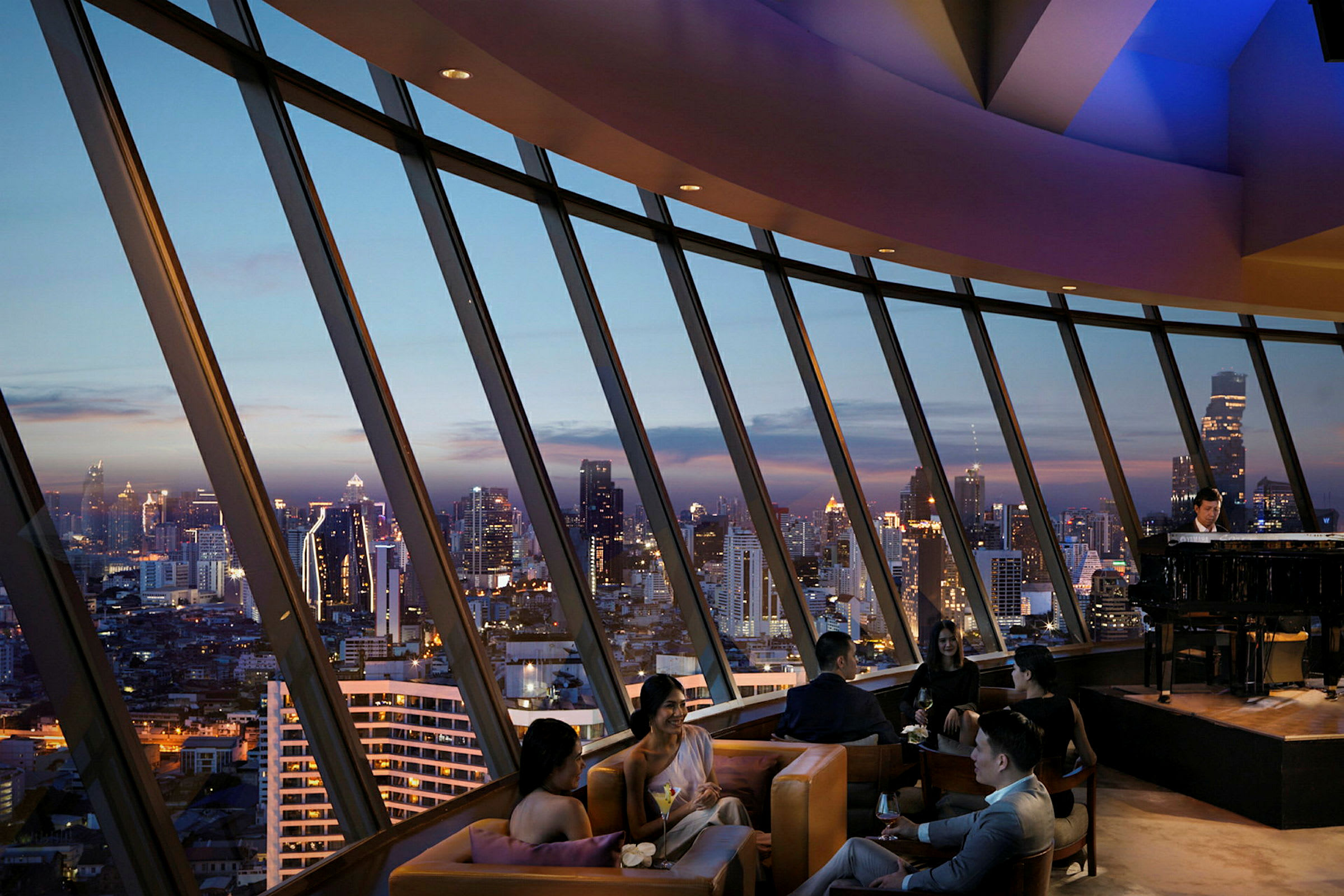 Folk sidder i en luksuriøs lounge med panoramaudsigt over byens skyline ved skumring. (AI-genereret tekst)