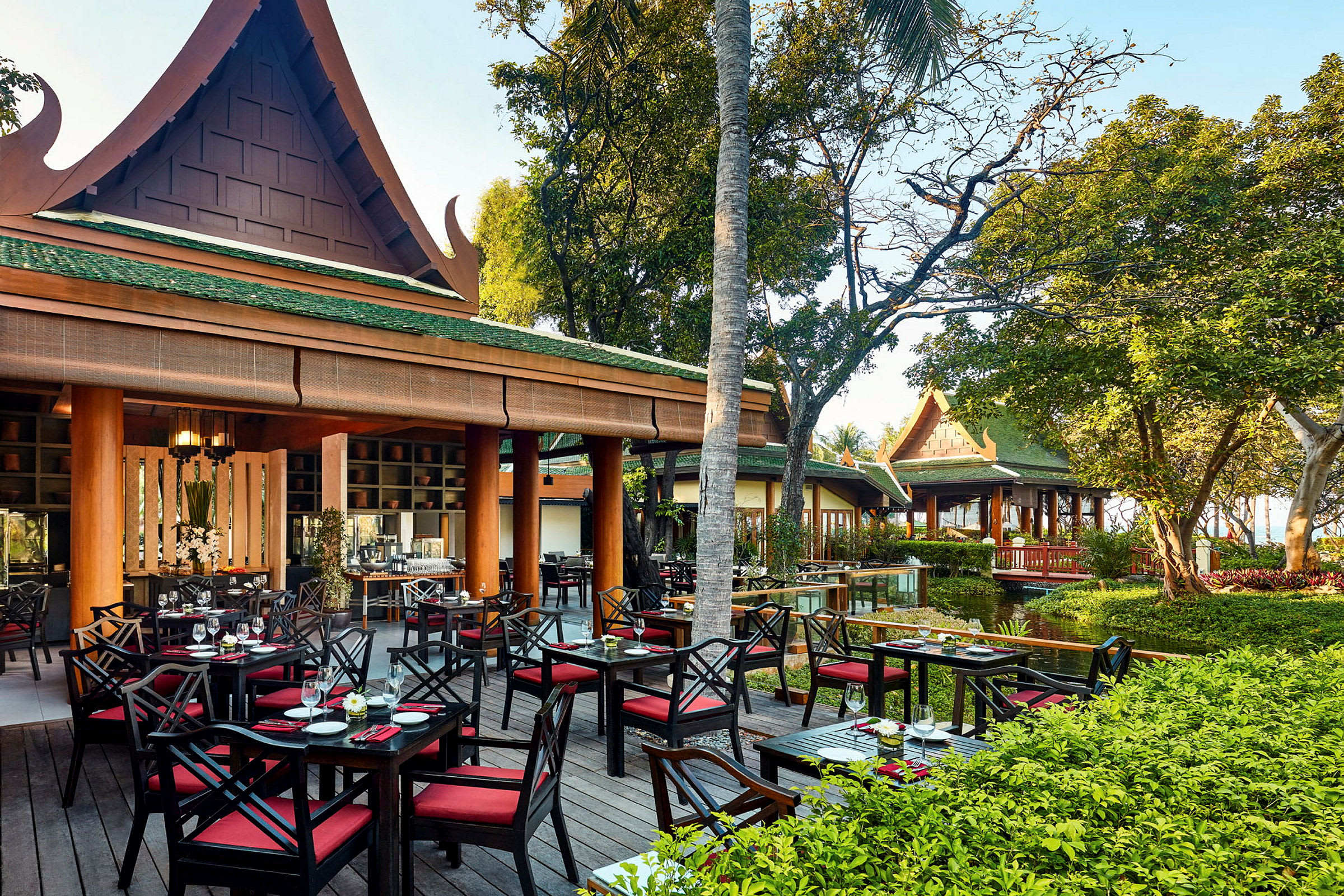 Udendørs restaurant med traditionel asiatisk arkitektur omgivet af vegetation. (AI-genereret tekst)