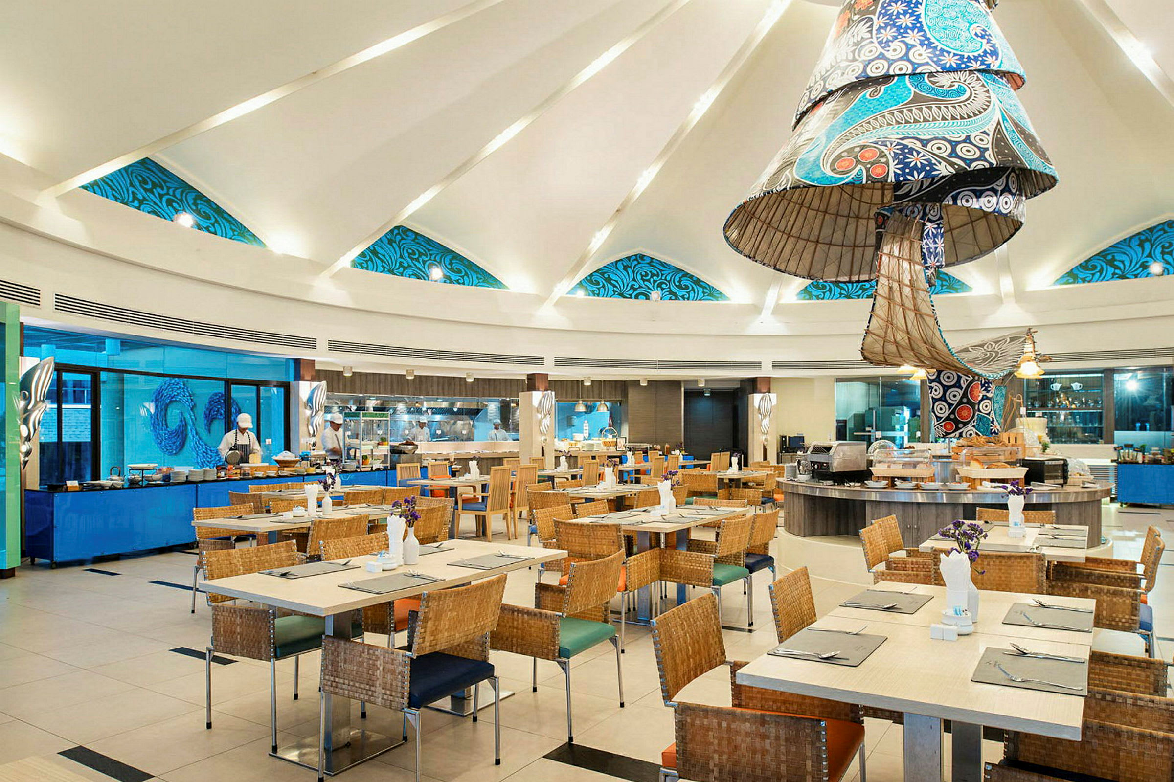 Billede af en moderne restaurant med dekorerede loftdetaljer, borde og stole i flettet stil. (AI-genereret tekst)