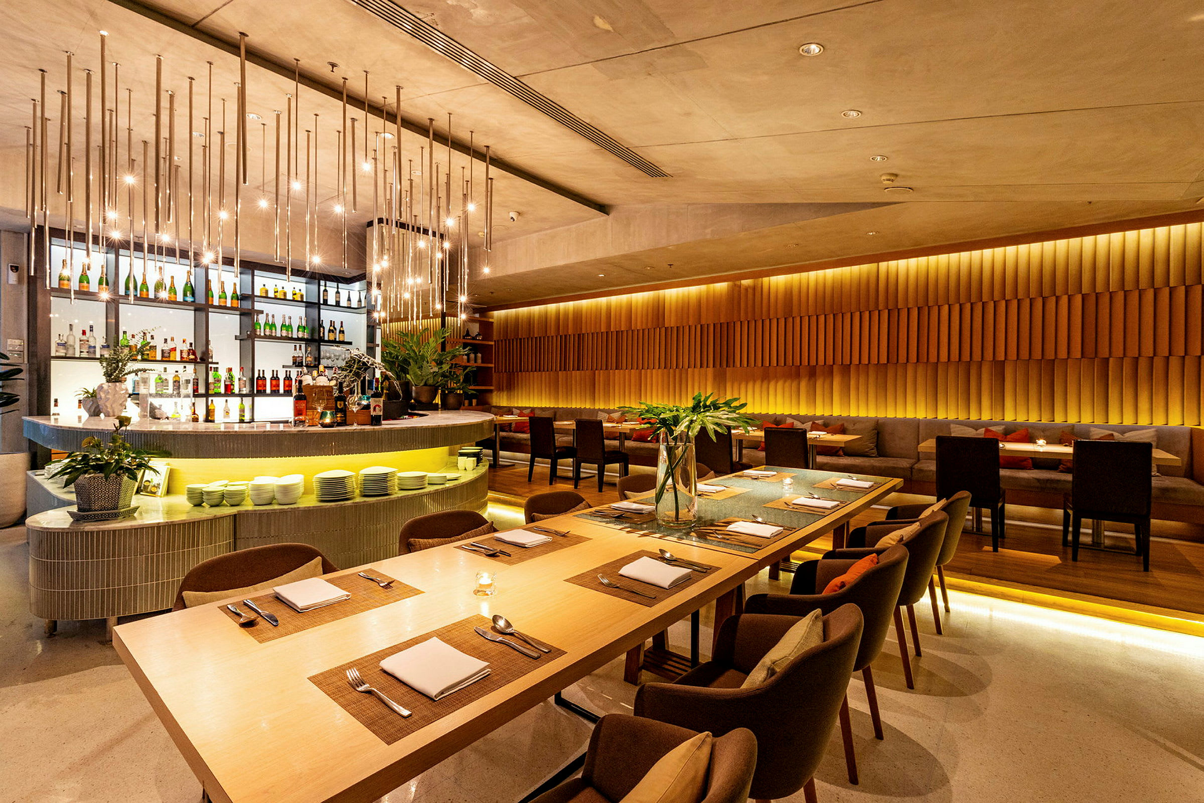 En elegant restaurant med moderne interiør, dekorative lamper i loftet og dækkede borde. (AI-genereret tekst)