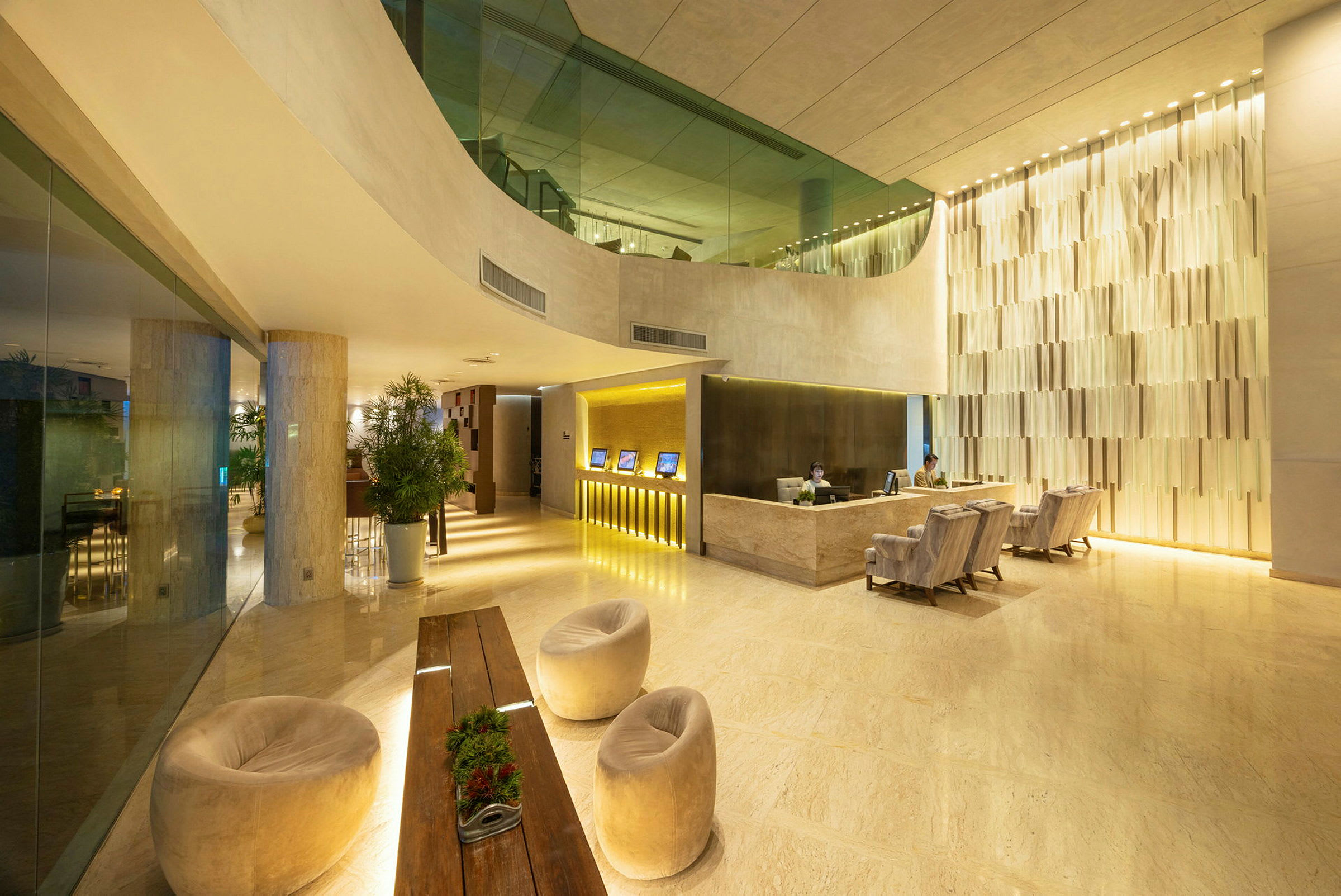 En moderne hotellobby med reception, siddepladser og dekorative planter. (AI-genereret tekst)