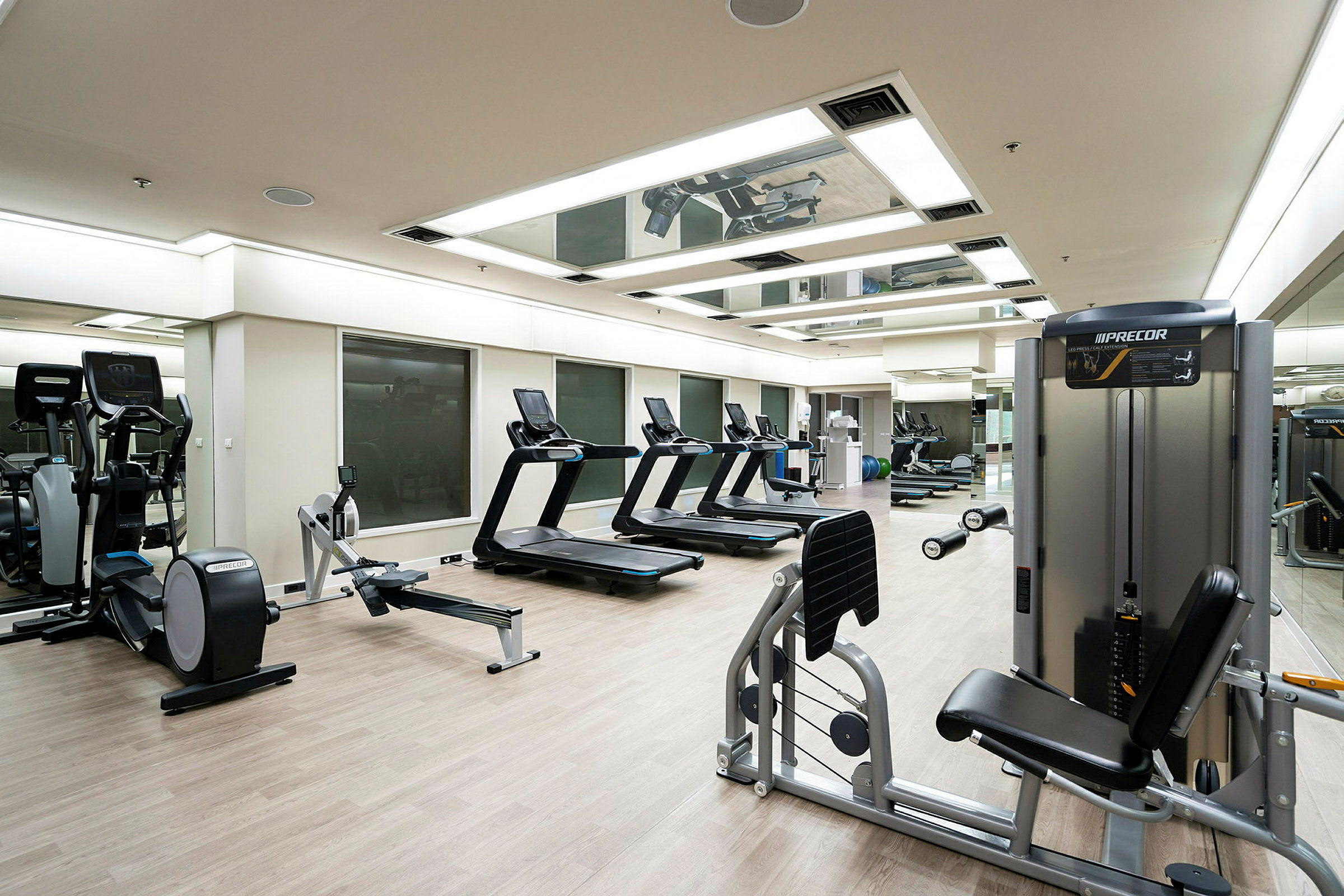 Et fitnesscenter med træningsmaskiner som løbebånd, romaskiner og styrketræningsudstyr. (AI-genereret tekst)