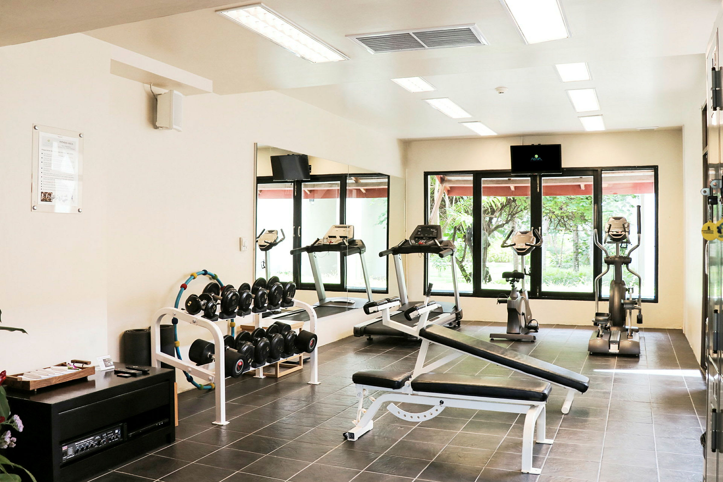 Billede af et fitnesscenter med træningsudstyr som løbebånd og håndvægte. (AI-genereret tekst)