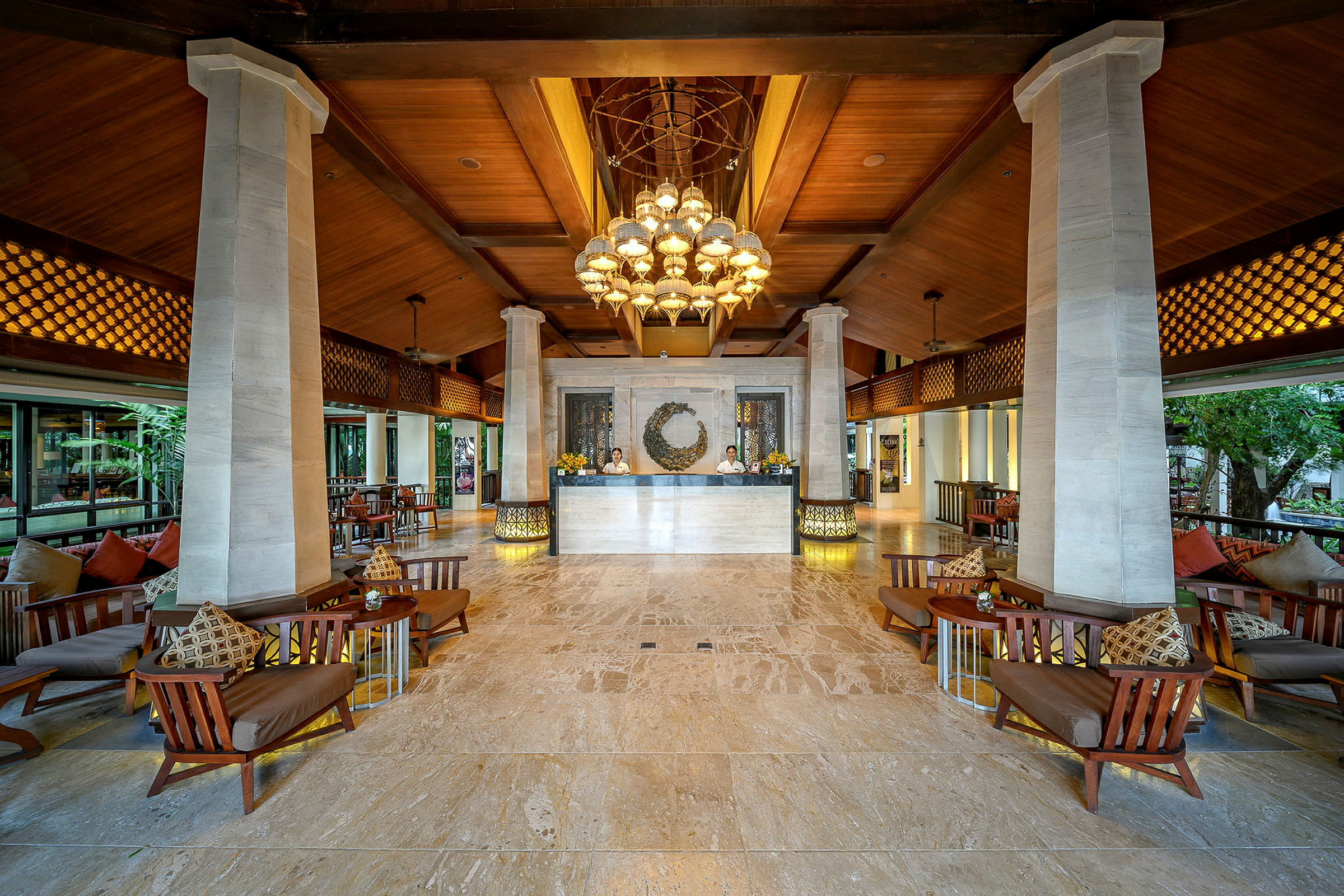 En åben og elegant hotellobby med højt træloft, marmorgulv, siddepladser og en reception. (AI-genereret tekst)