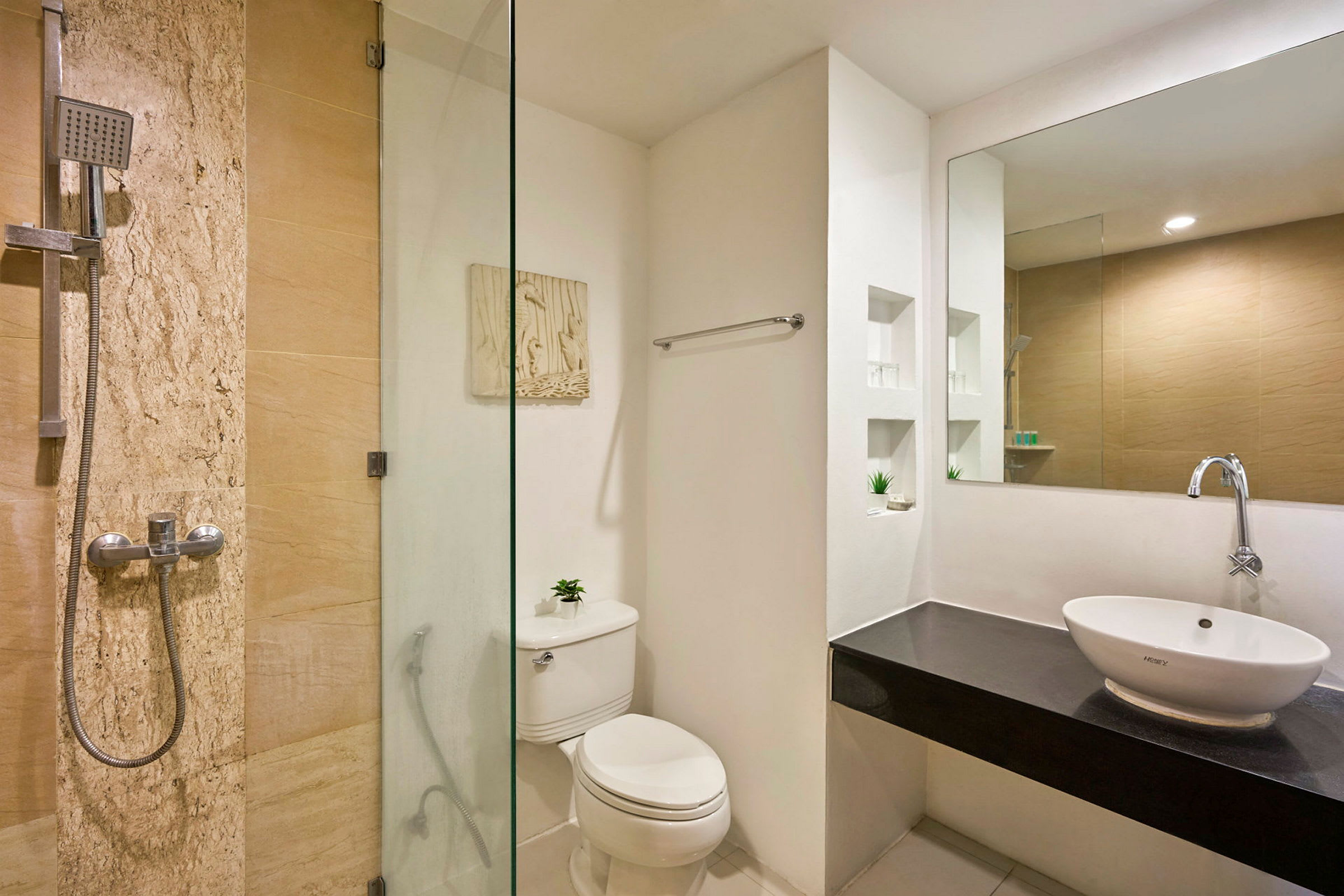 Et badeværelse med bruser, toilet og håndvask i moderne og stilrent design. (AI-genereret tekst)