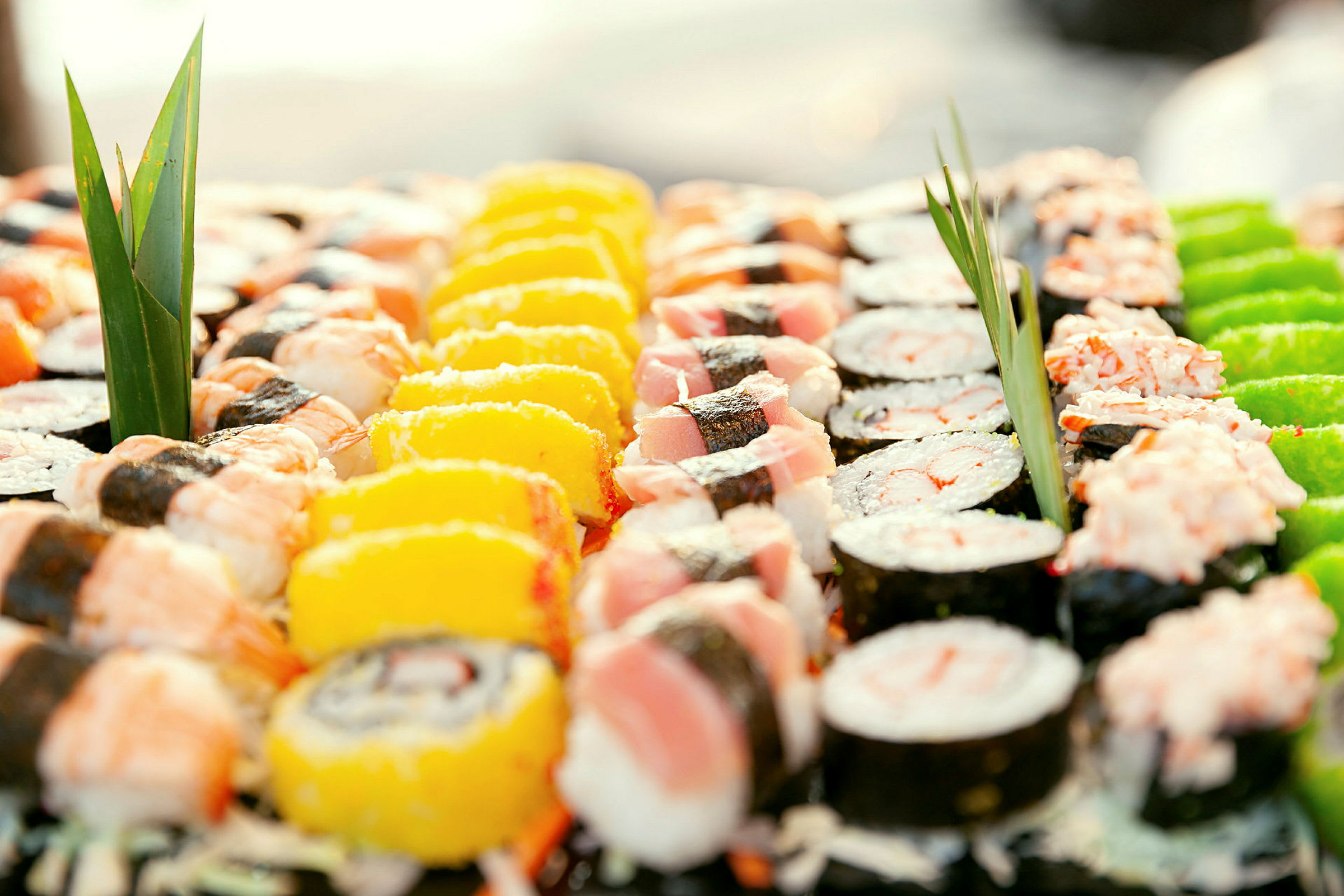 Et nærbillede af forskellige slags sushi arrangeret med dekorative blade. (AI-genereret tekst)