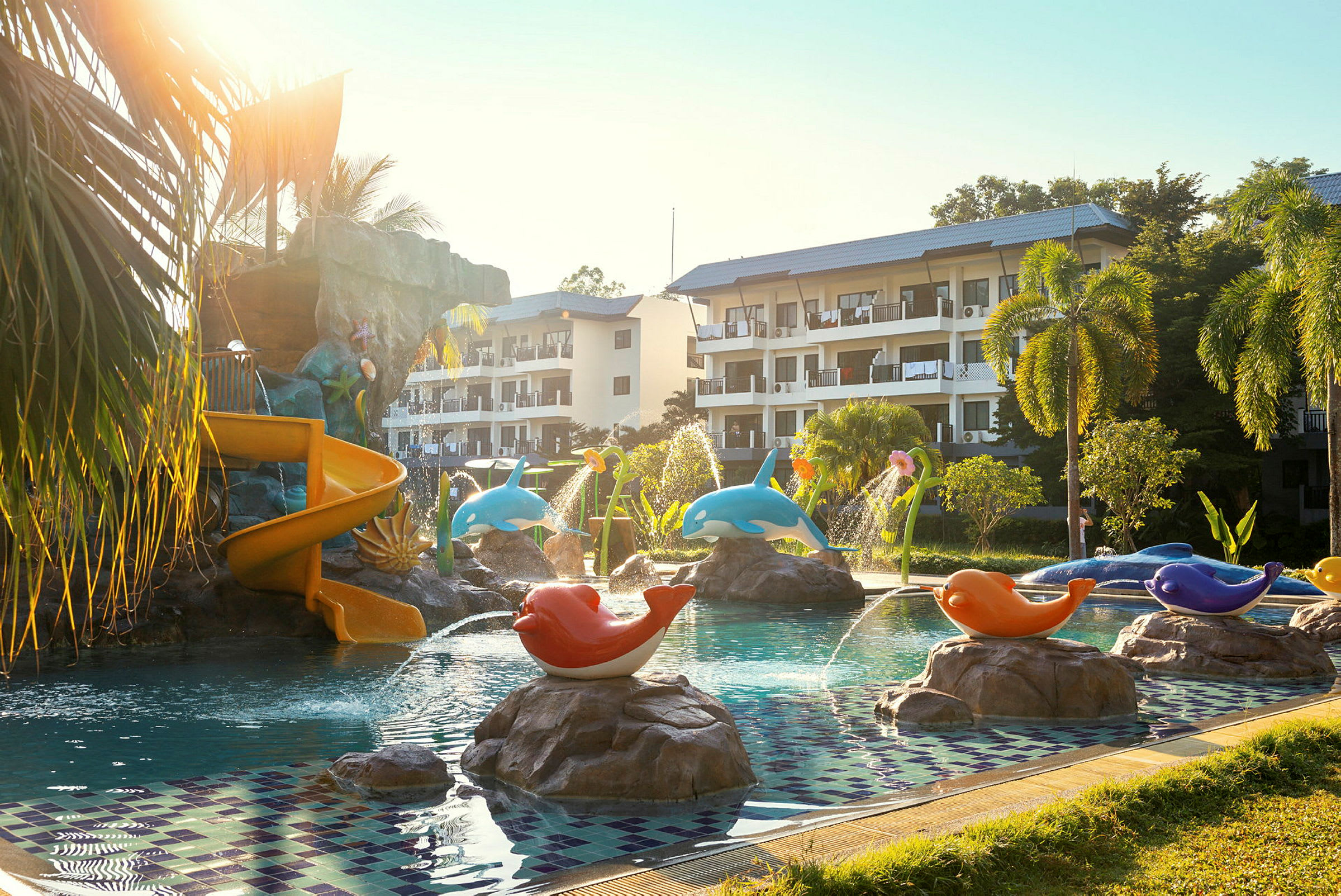Udendørs pool med børnevenlige dekorationer og rutsjebane ved hotelområde. (AI-genereret tekst)