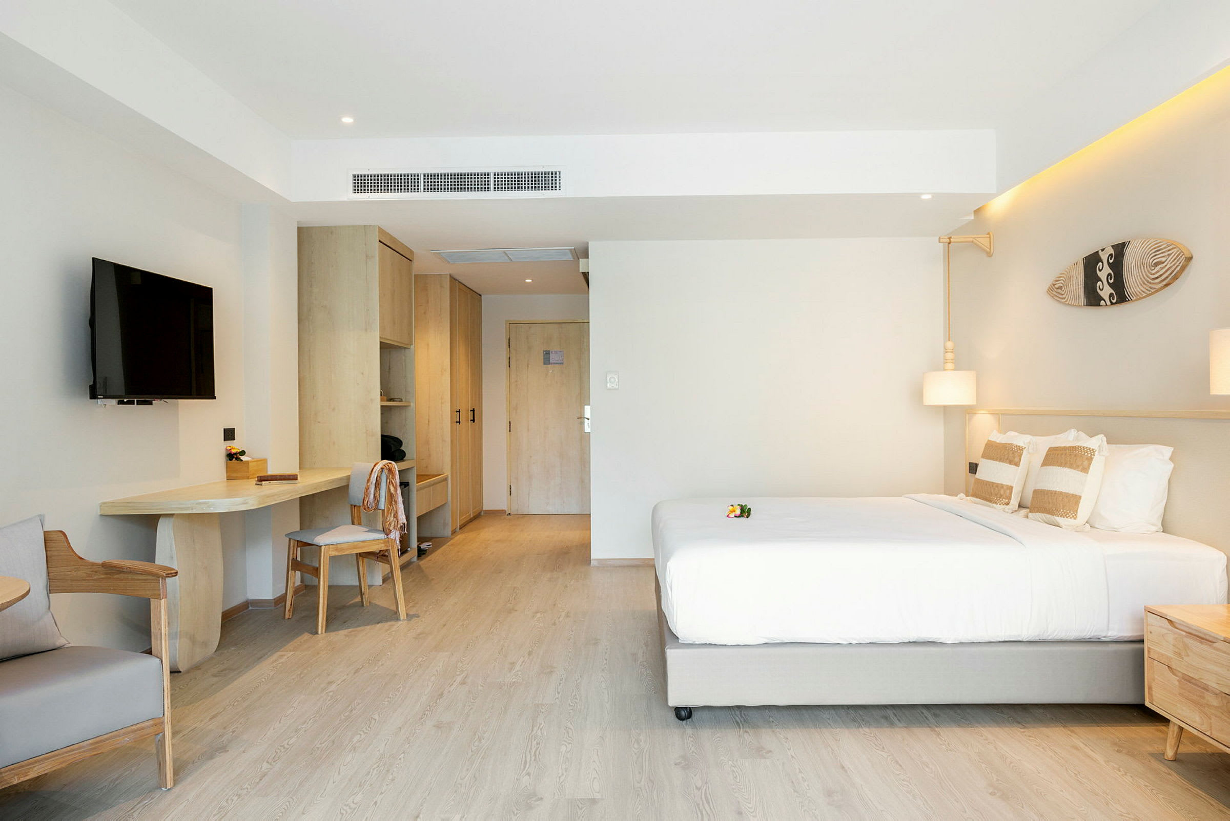 Et moderne hotelværelse med en dobbeltseng, TV, skrivebord og garderobe. (AI-genereret tekst)